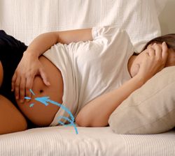 donna in gravidanza sdraiata con una mano davanti al viso