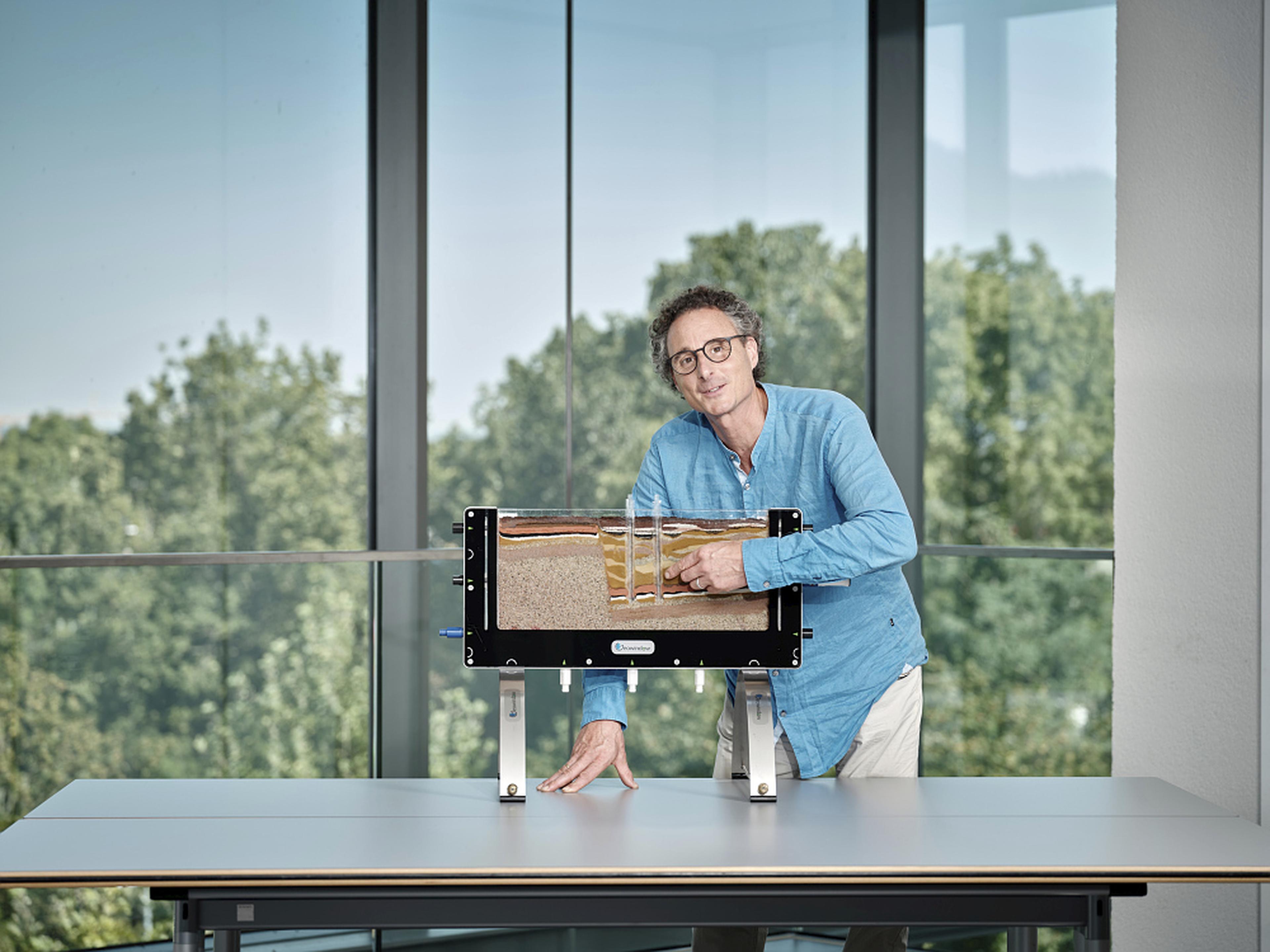 Mann zeigt Gesteinsschichten in einem Geowindow