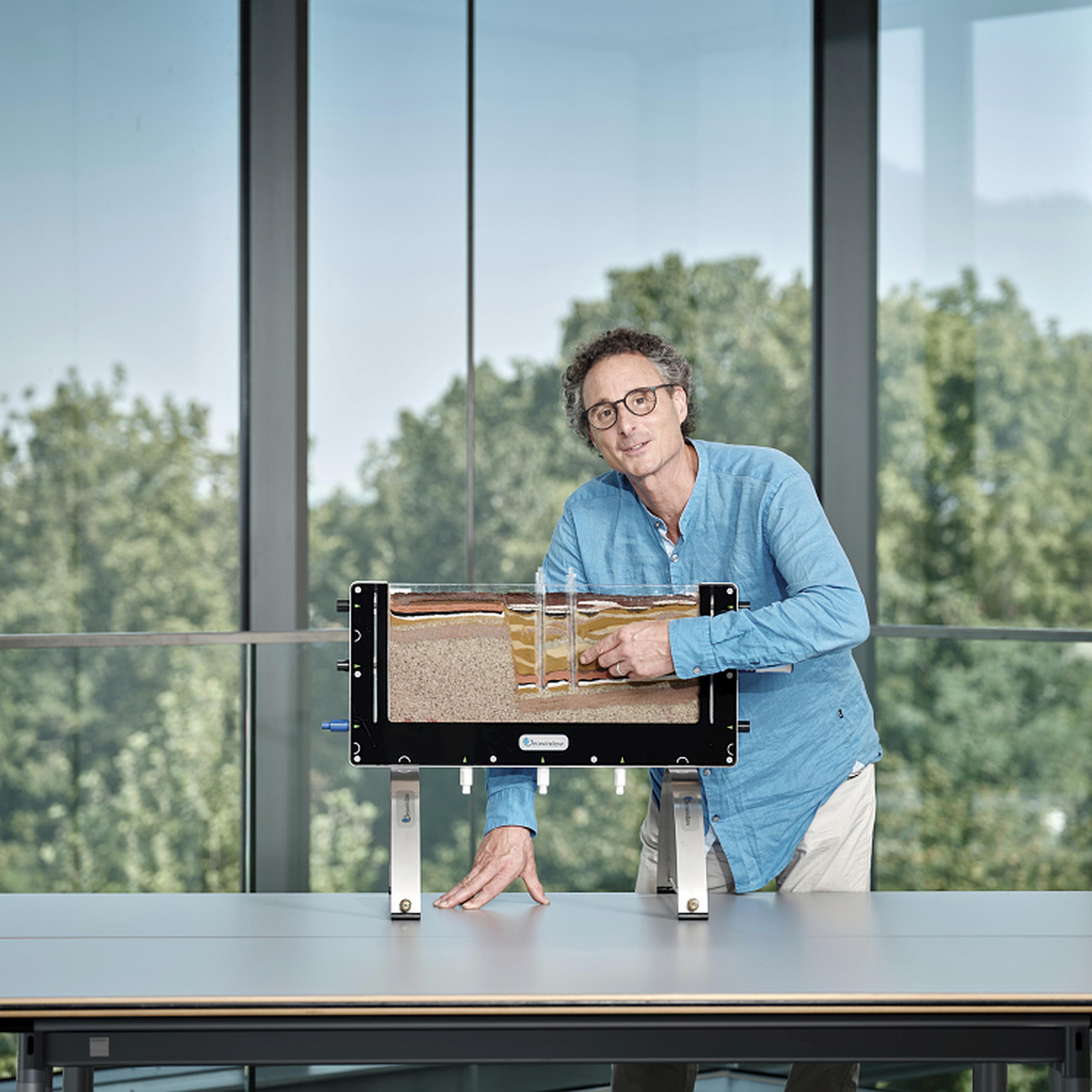 Mann zeigt Gesteinsschichten in einem Geowindow