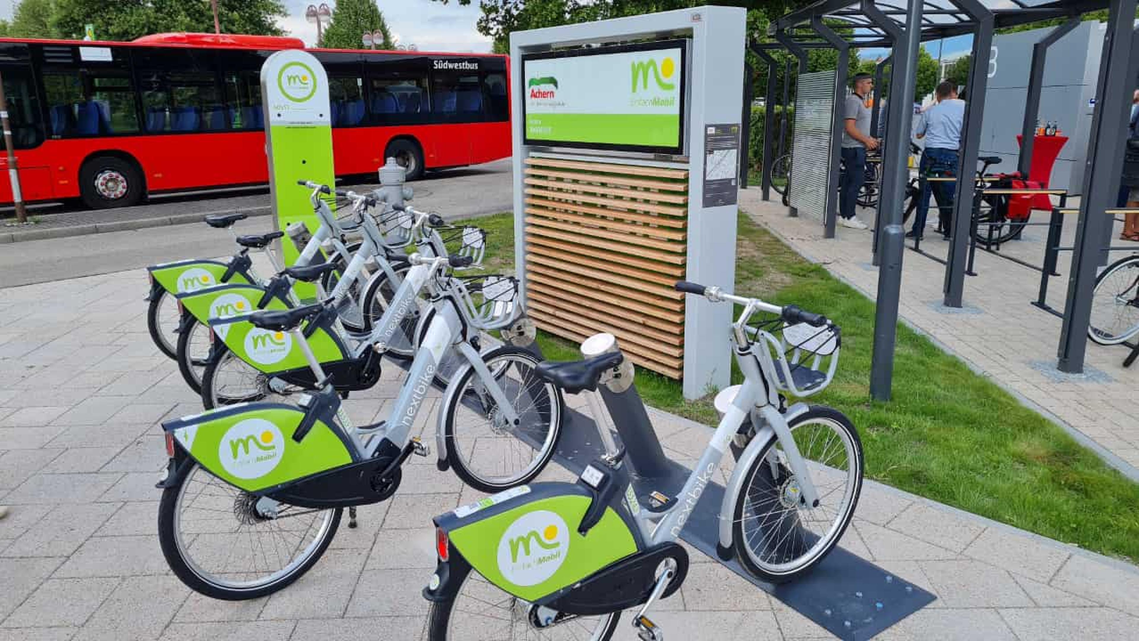 Sharing-Systeme und ÖPNV als attraktive Auto-Alternative im ländlichen Raum – dargestellt durch Fahrradverleih und Bus.