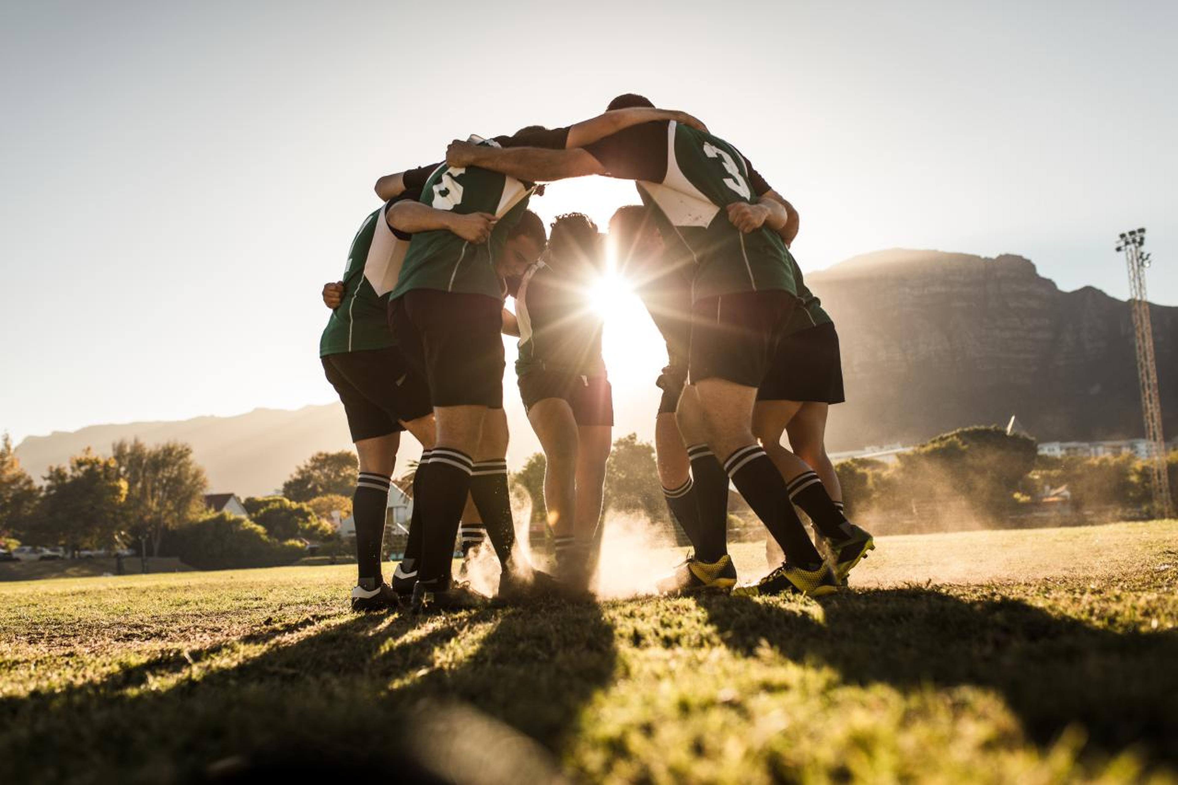 Badenova Crowdfunding Plattform - ein Fußballteam umarmt sich auf dem Spielfeld im Sonnenlicht