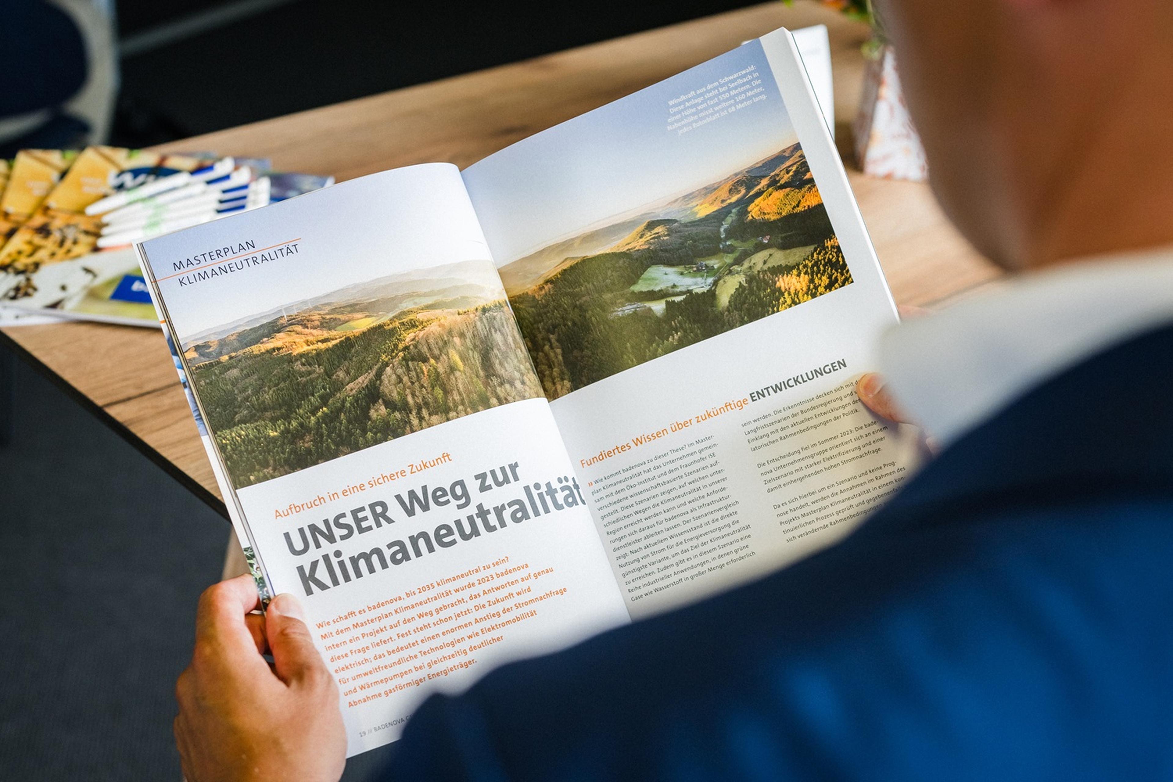 Eine Person hat den Geschaeftsbericht aufgeschlagen