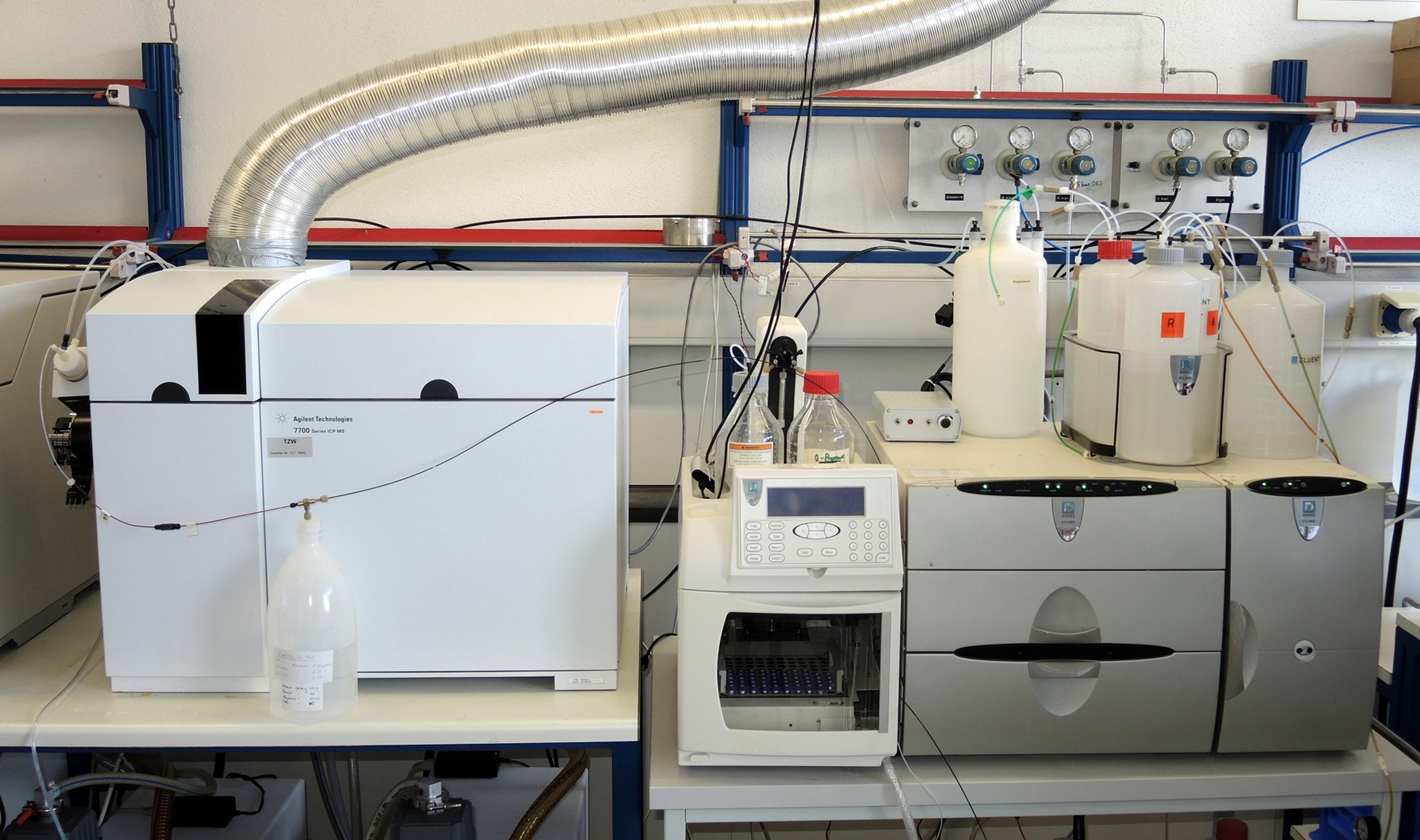 Eine Laborausstattung umfasst moderne wissenschaftliche Geräte mit angeschlossenen Schläuchen und Behältern, die für chemische Analysen oder Experimente verwendet werden.