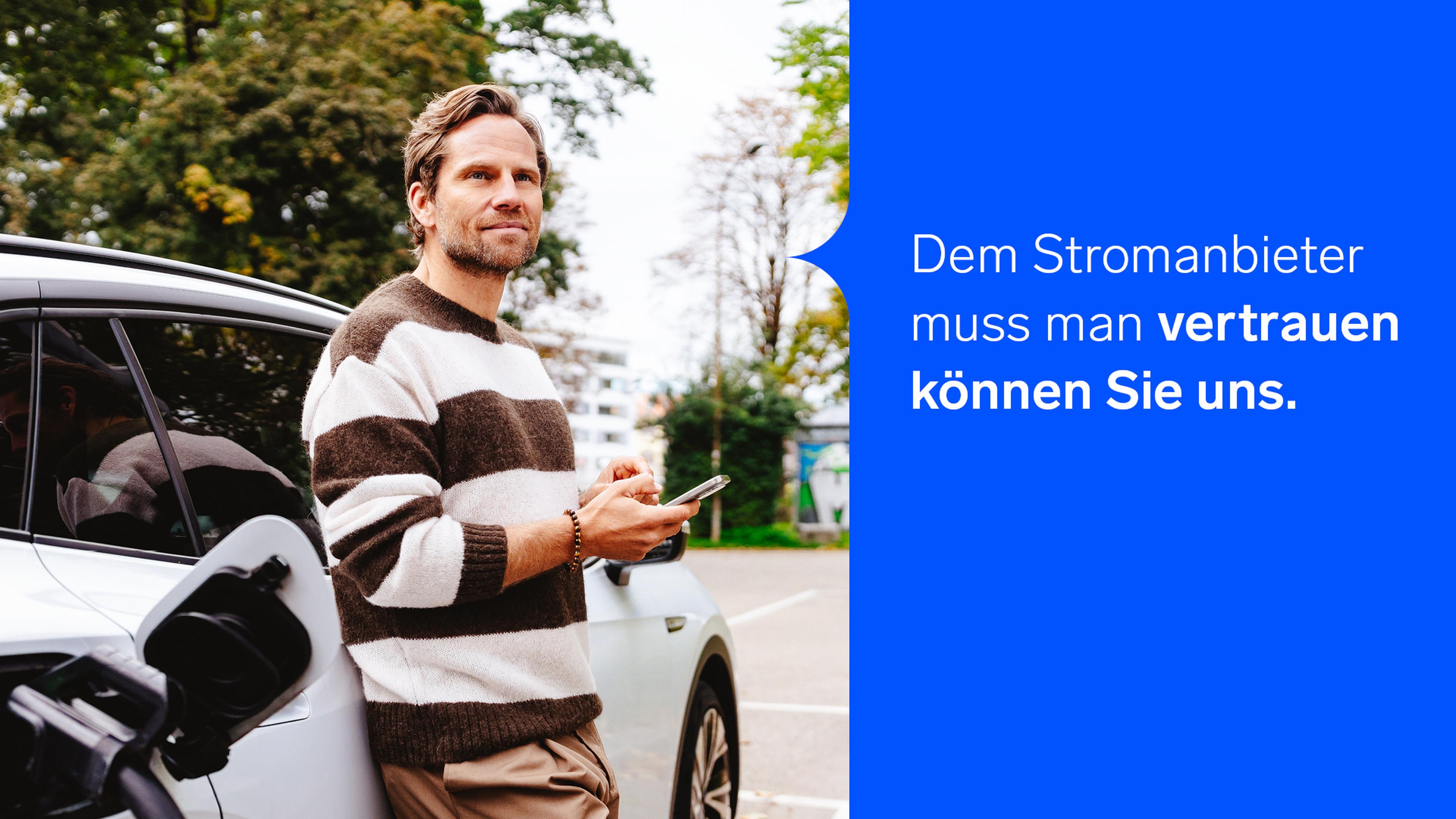 Mann, der an einem Auto lehnt, ein Telefon in der Hand hält und einen blauen Textbereich mit einer Werbung für einen Stromanbieter zeigt, die Vertrauen vermittelt.