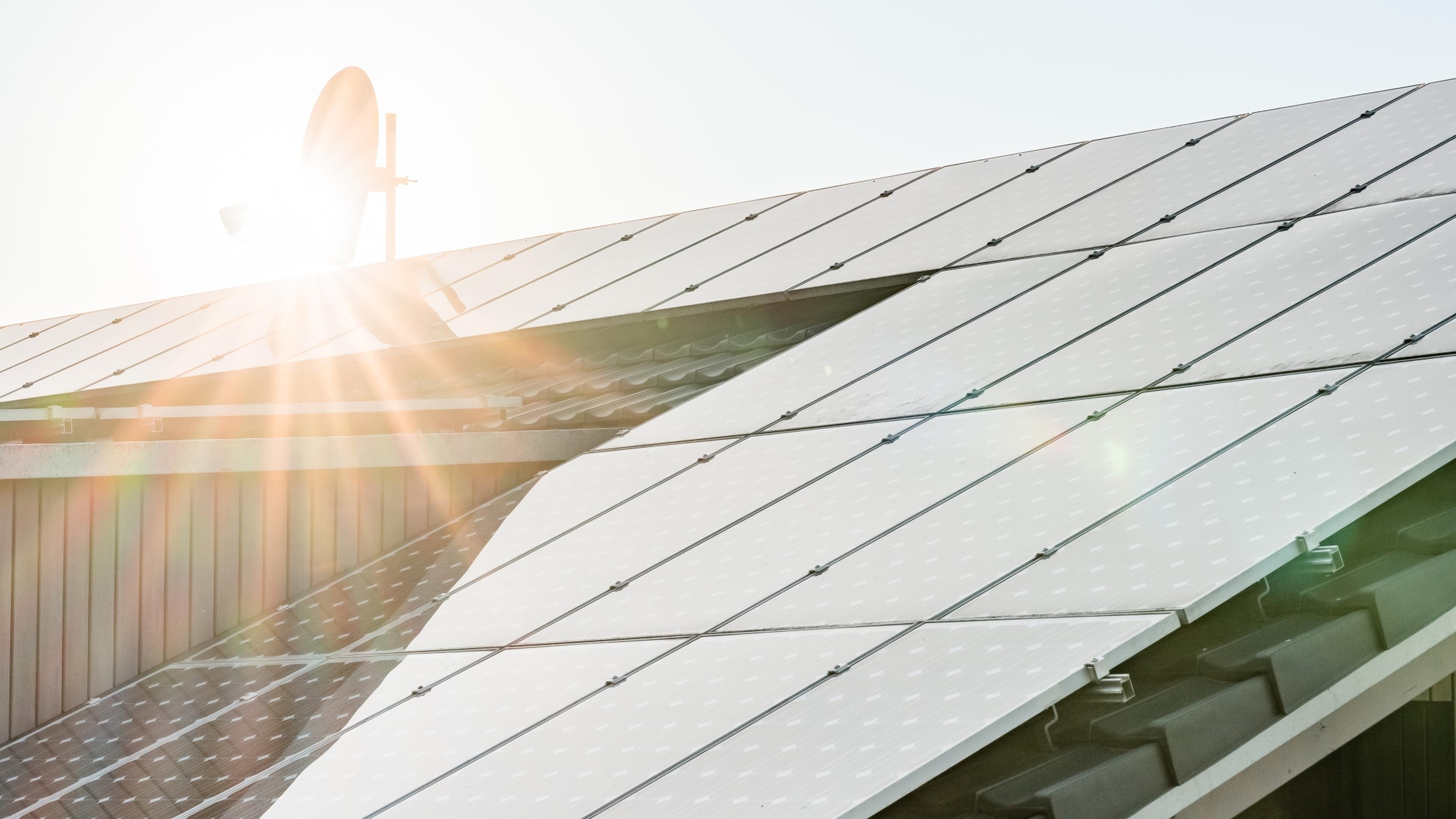 Eine PV-Anlage auf einem Wohngebäude im Abendlicht.
