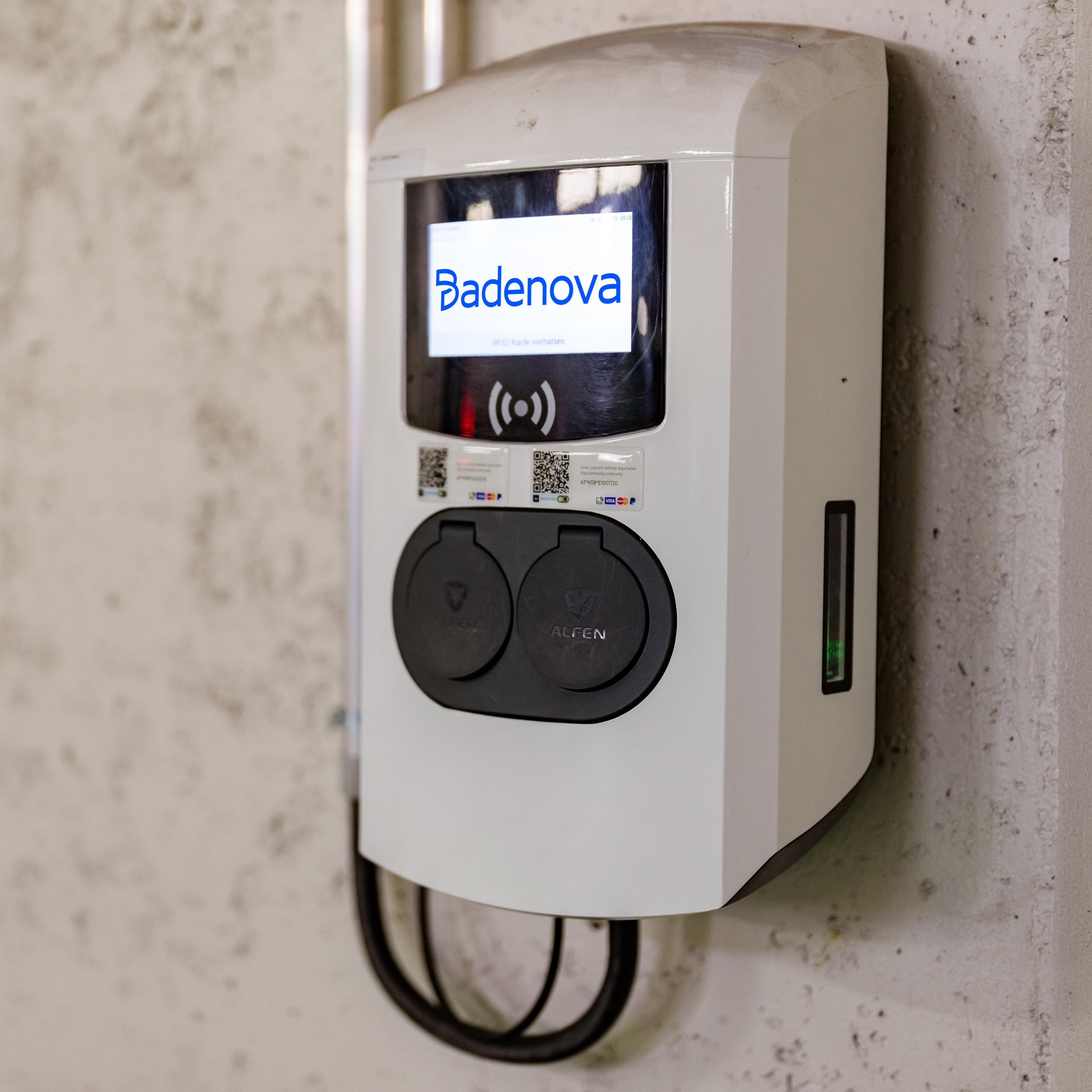 Eine Wallbox hängt an einer Wand in einer Tiefgarage.
