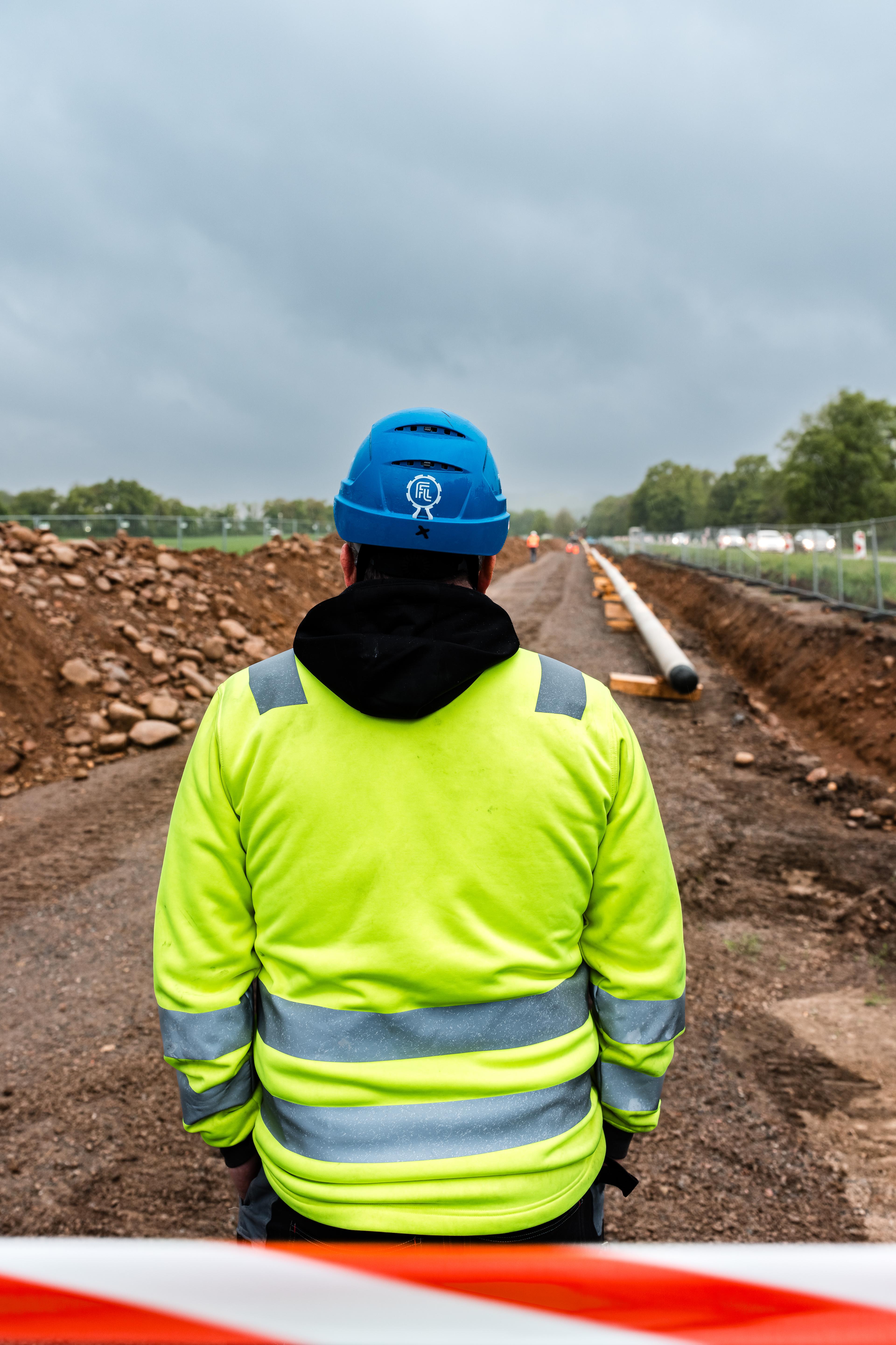 Bauarbeiter sitzt auf einer Wasserstoffleitungsbaustelle