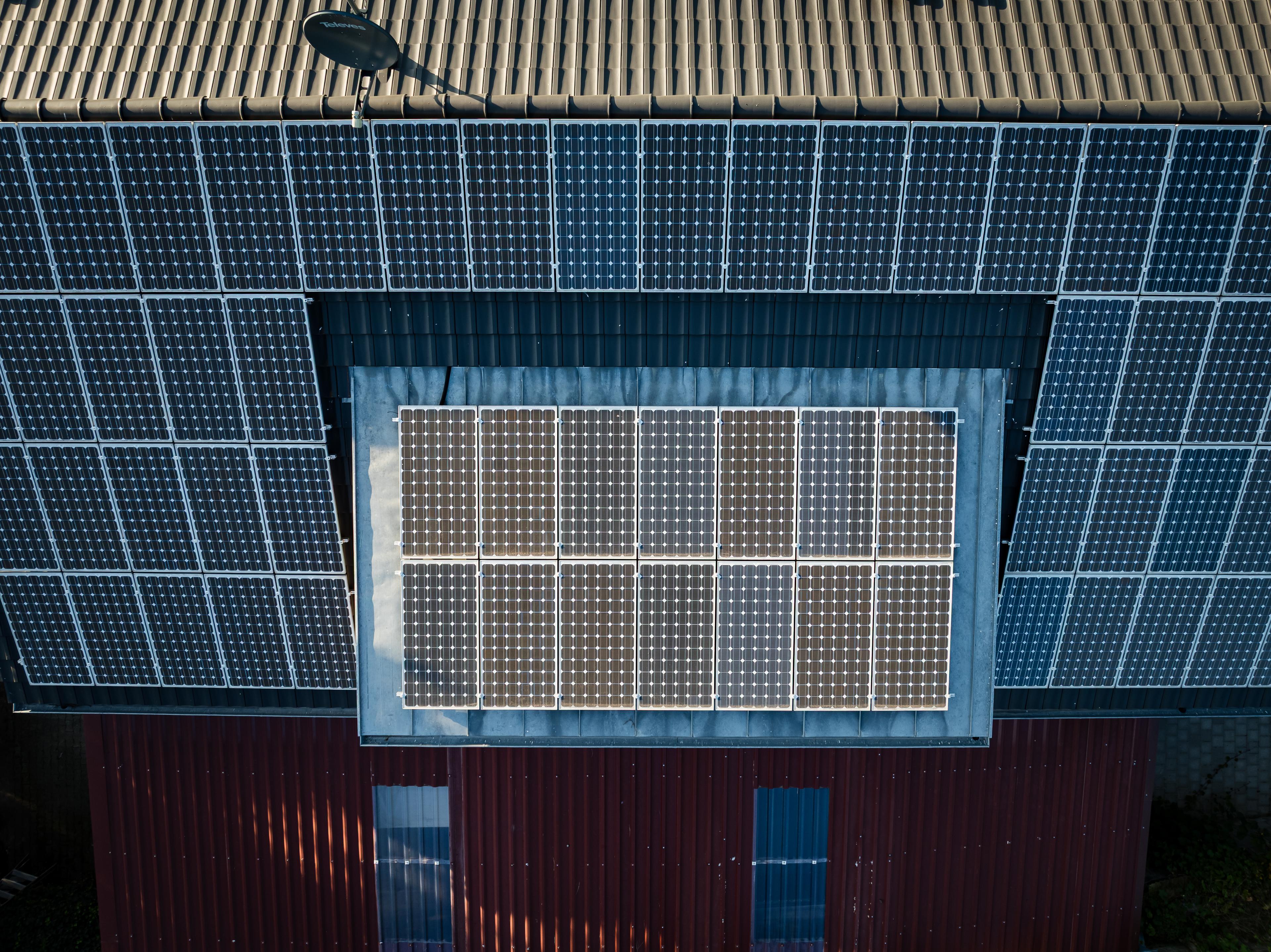 Solarpanele auf einem braunen Dach in Vogelperspektive