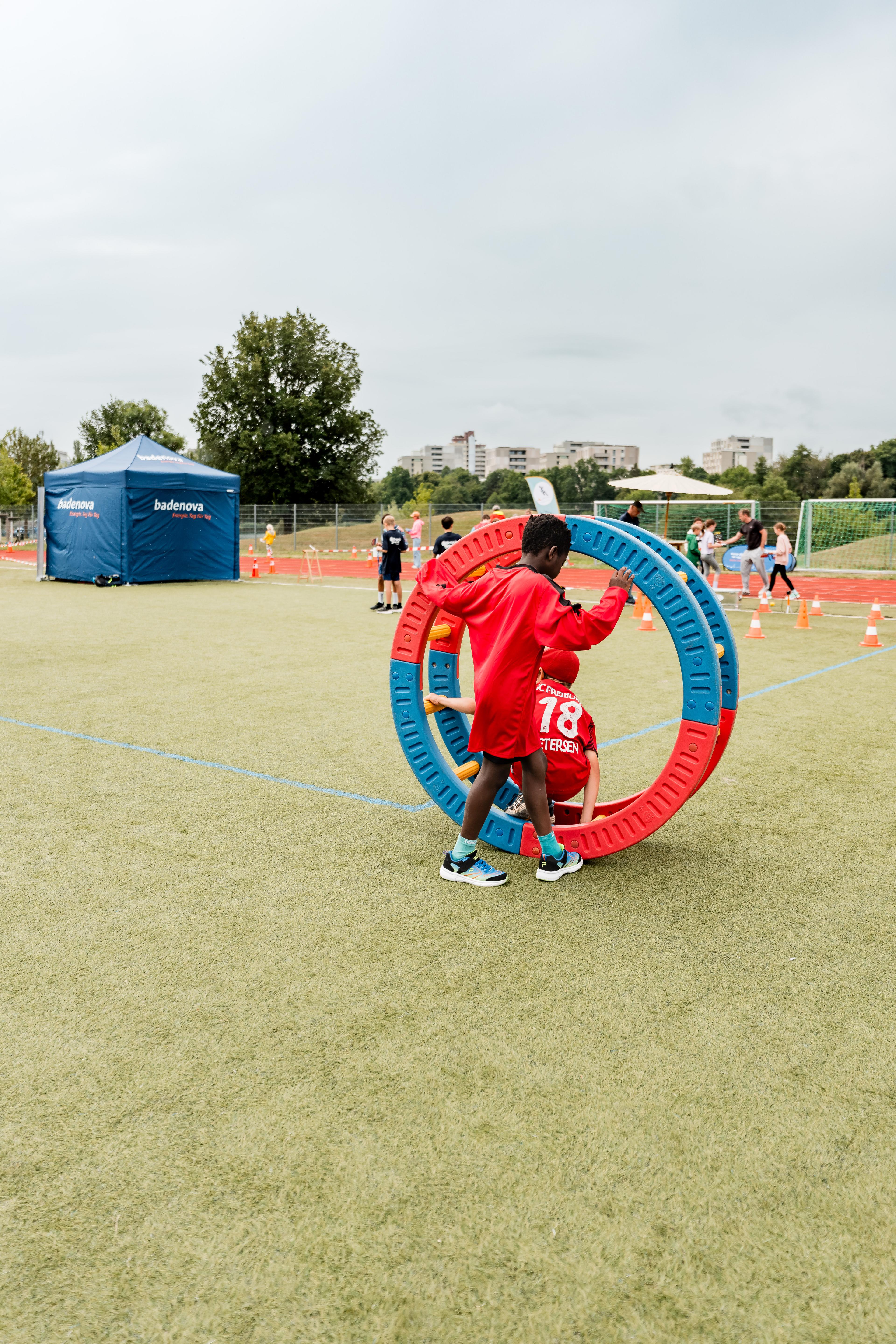 Kinder Spielen mit einem akrobatischen Rad bei Badenova bewegt am Seepark in Freiburg