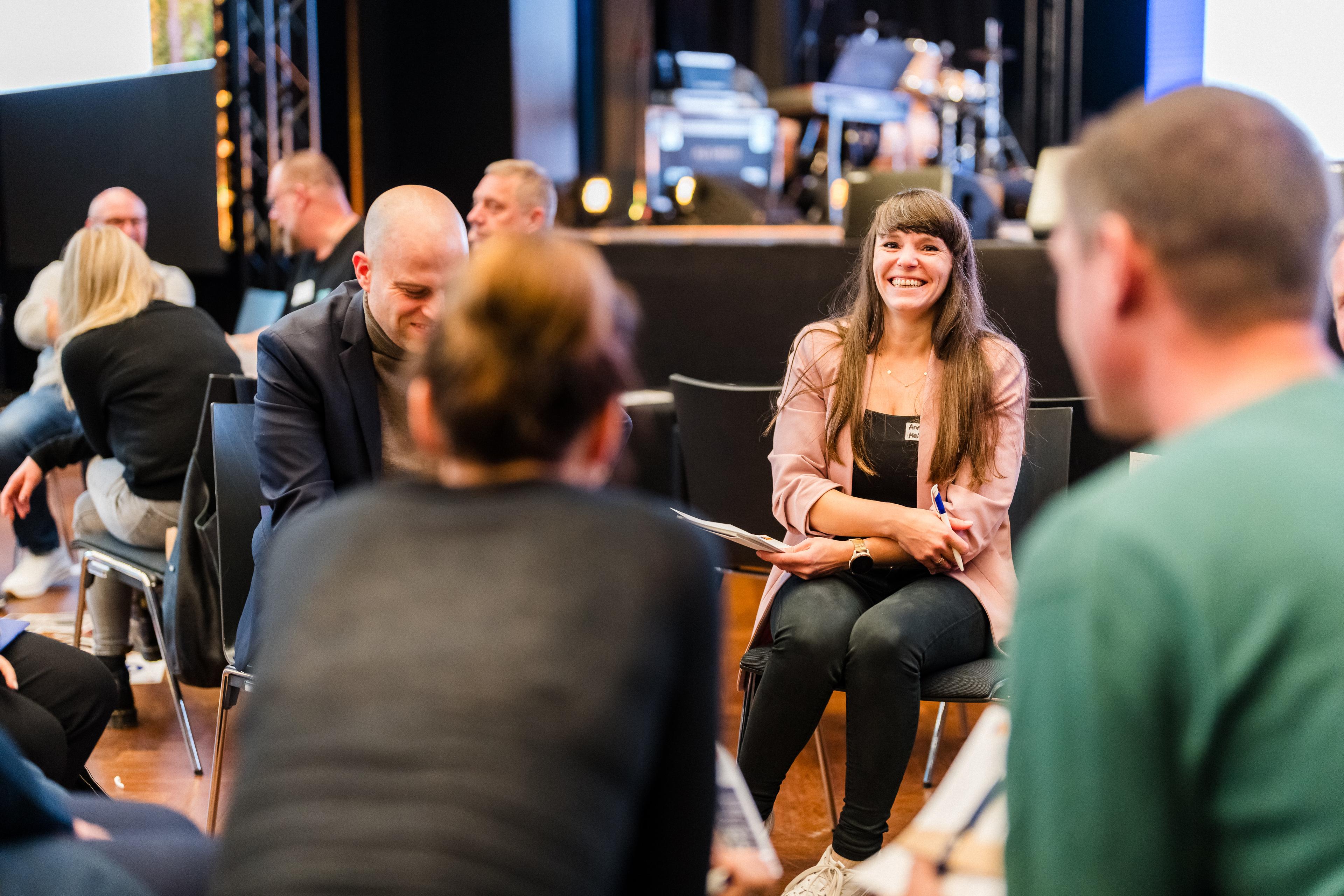 Mitarbeitende lacht herzlich in einer Arbeitsgruppe