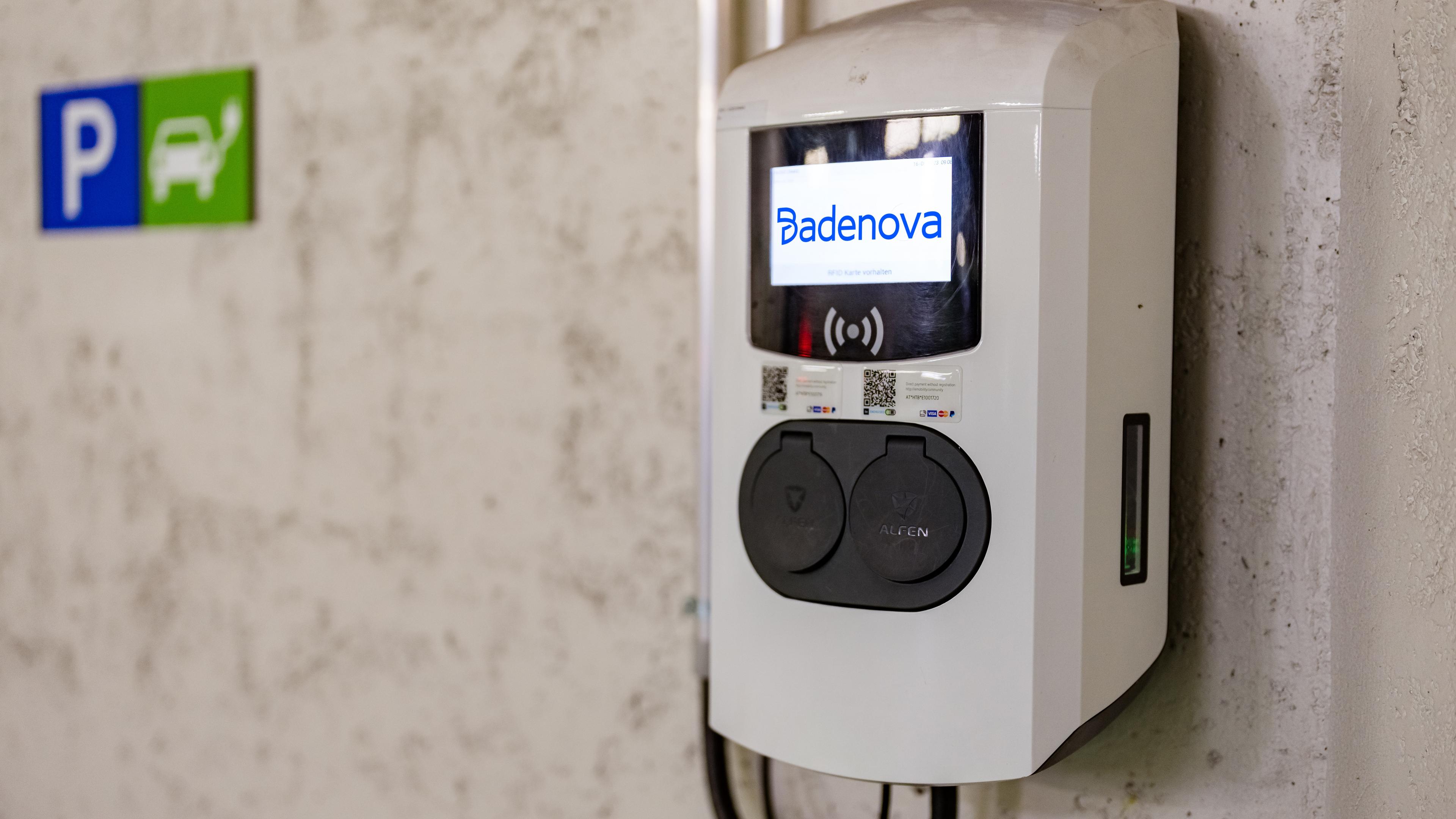 Eine Wallbox hängt an einer Wand in einer Tiefgarage.