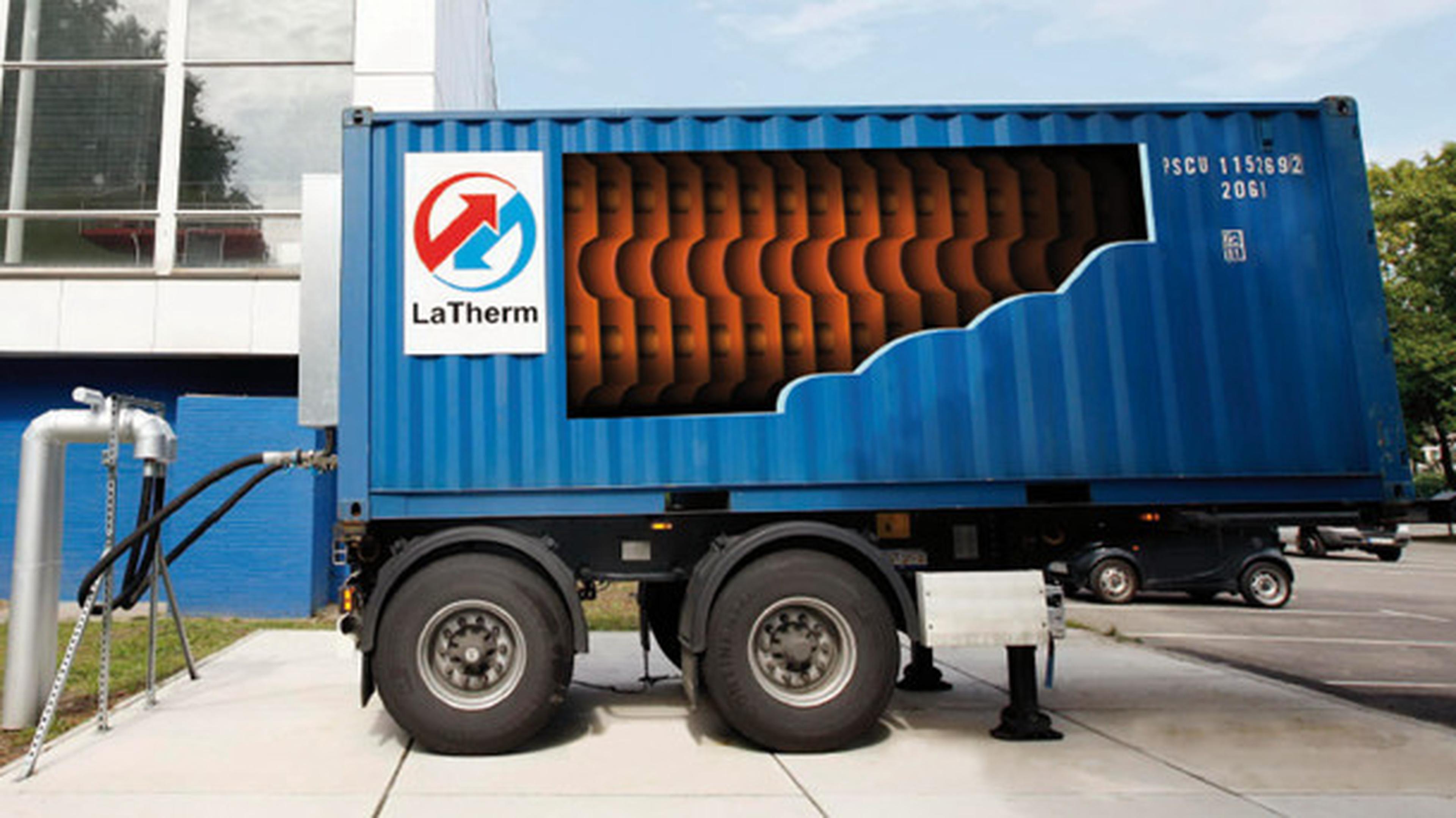 Ein blauer LaTherm-Behälter, der auf einem Anhänger montiert ist und dessen isolierte Wärmespeicherplatten sichtbar sind; er ist mit Rohrleitungen im Straßenbelag verbunden.