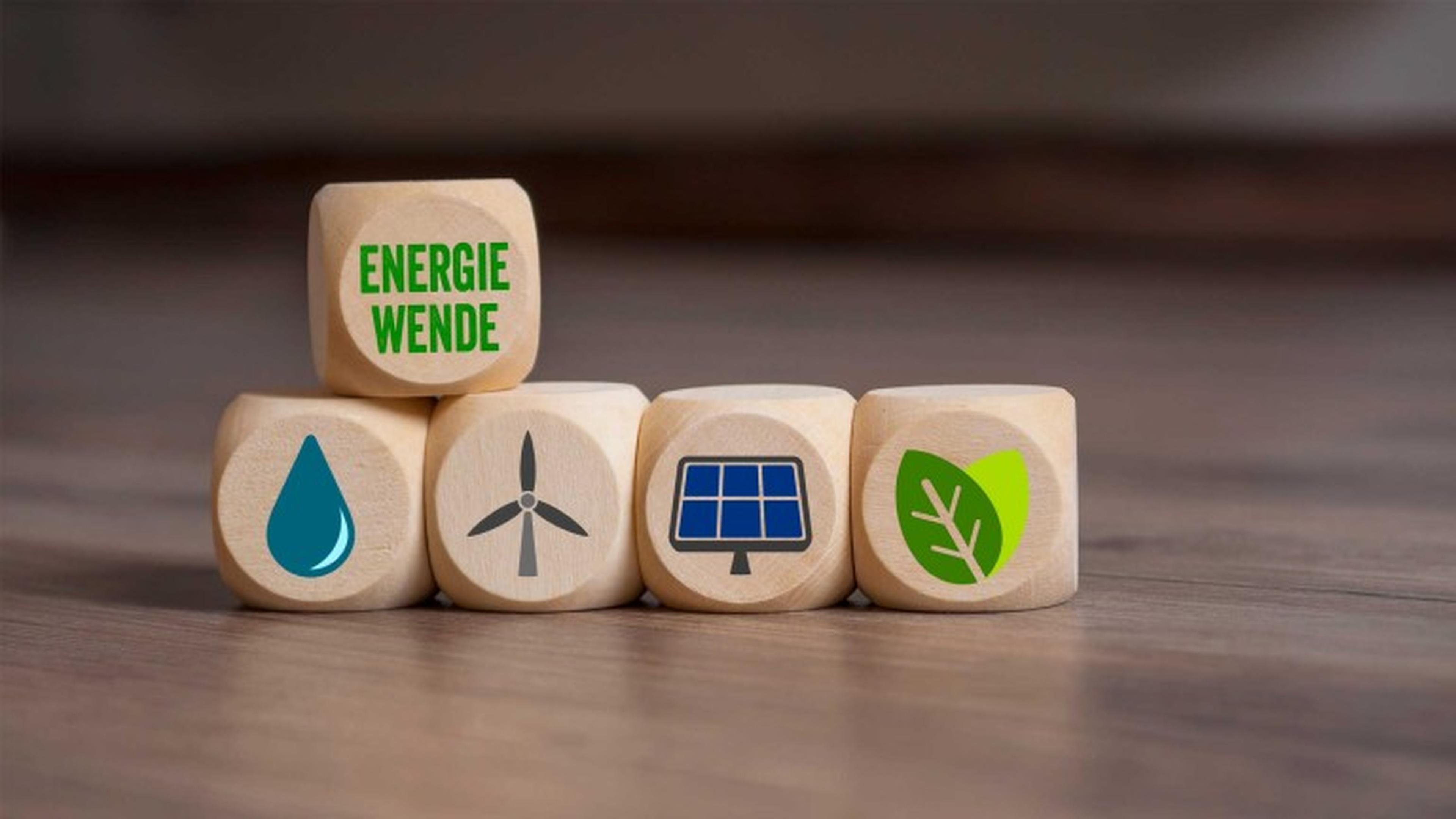 Holzklötze mit den Symbolen eines Wassertropfens, einer Windturbine, eines Solarpanels und eines Blattes, darüber ein Klötzchen mit der Aufschrift „Energiewende“.