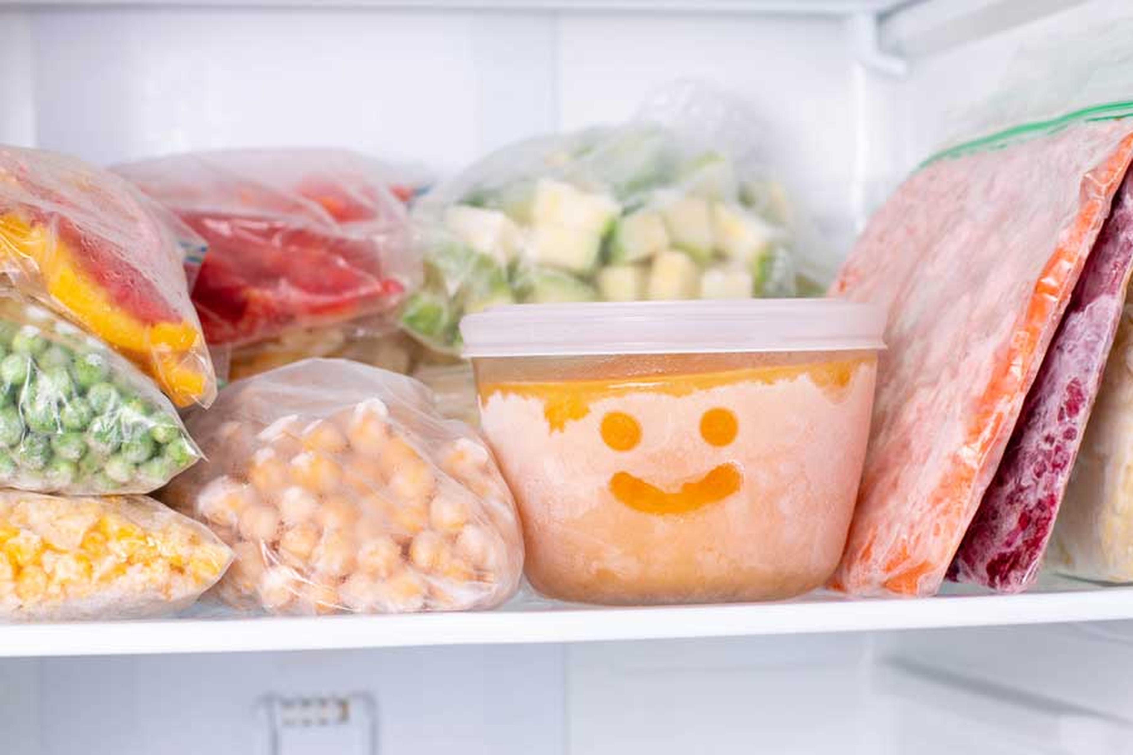 Gefrierschrank mit eingefrorenen Lebensmitteln in verschiedenen Behältnissen