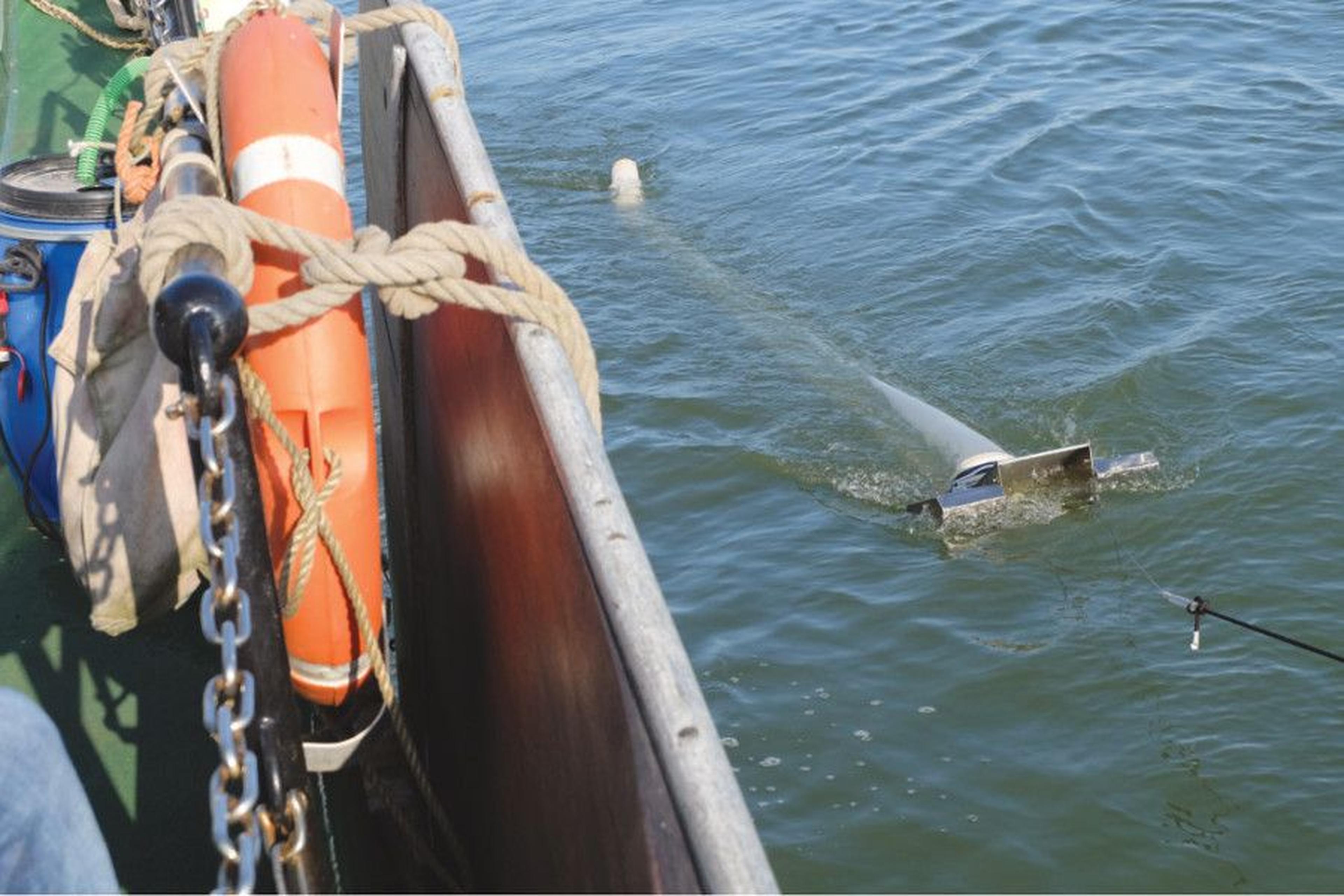 Messgerät wird von einem Boot aus durch Flusswasser gezogen.