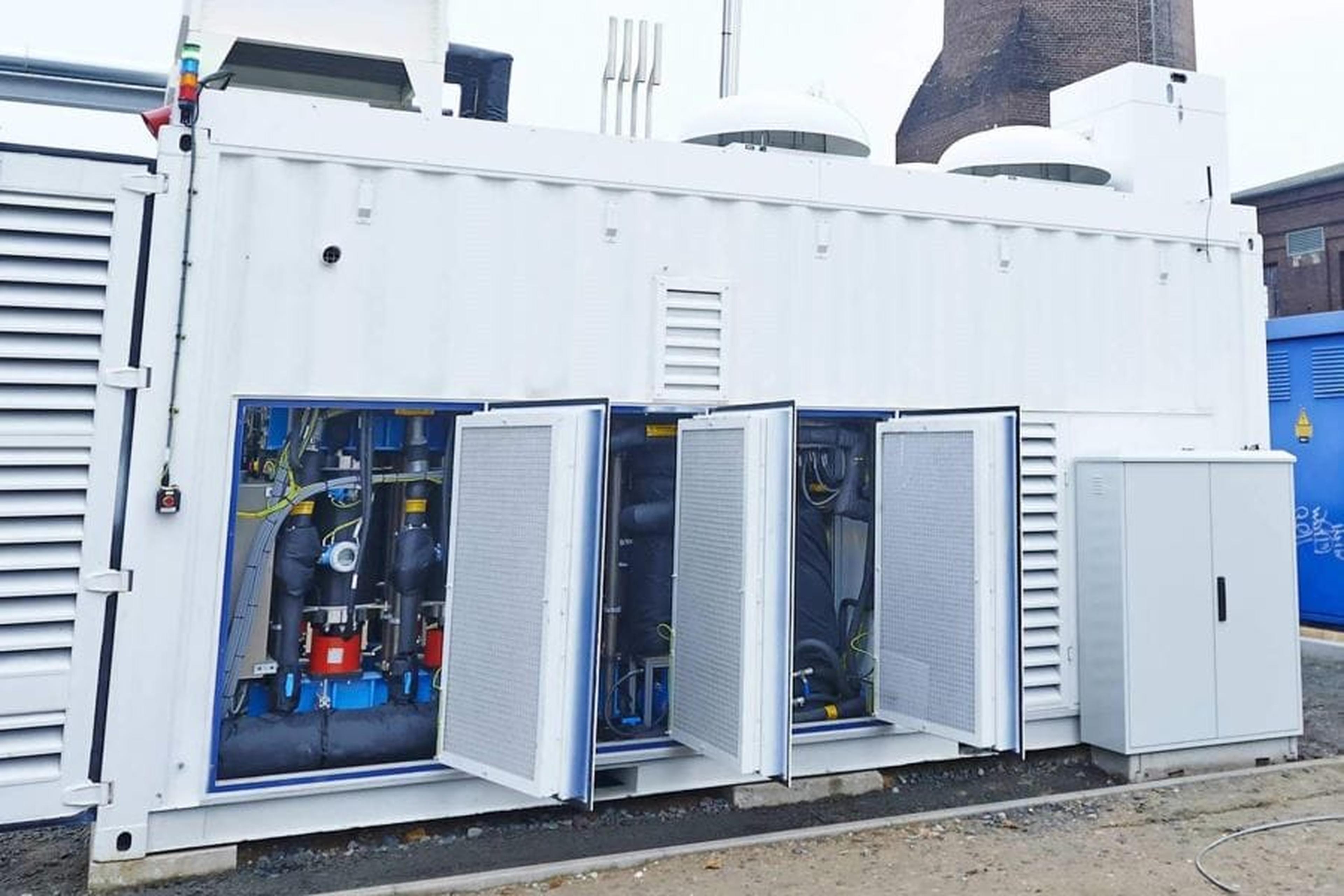 Ein großer weißer Technik-Container einer Power-to-Gas Anlage mit geöffneten Wartungsklappen