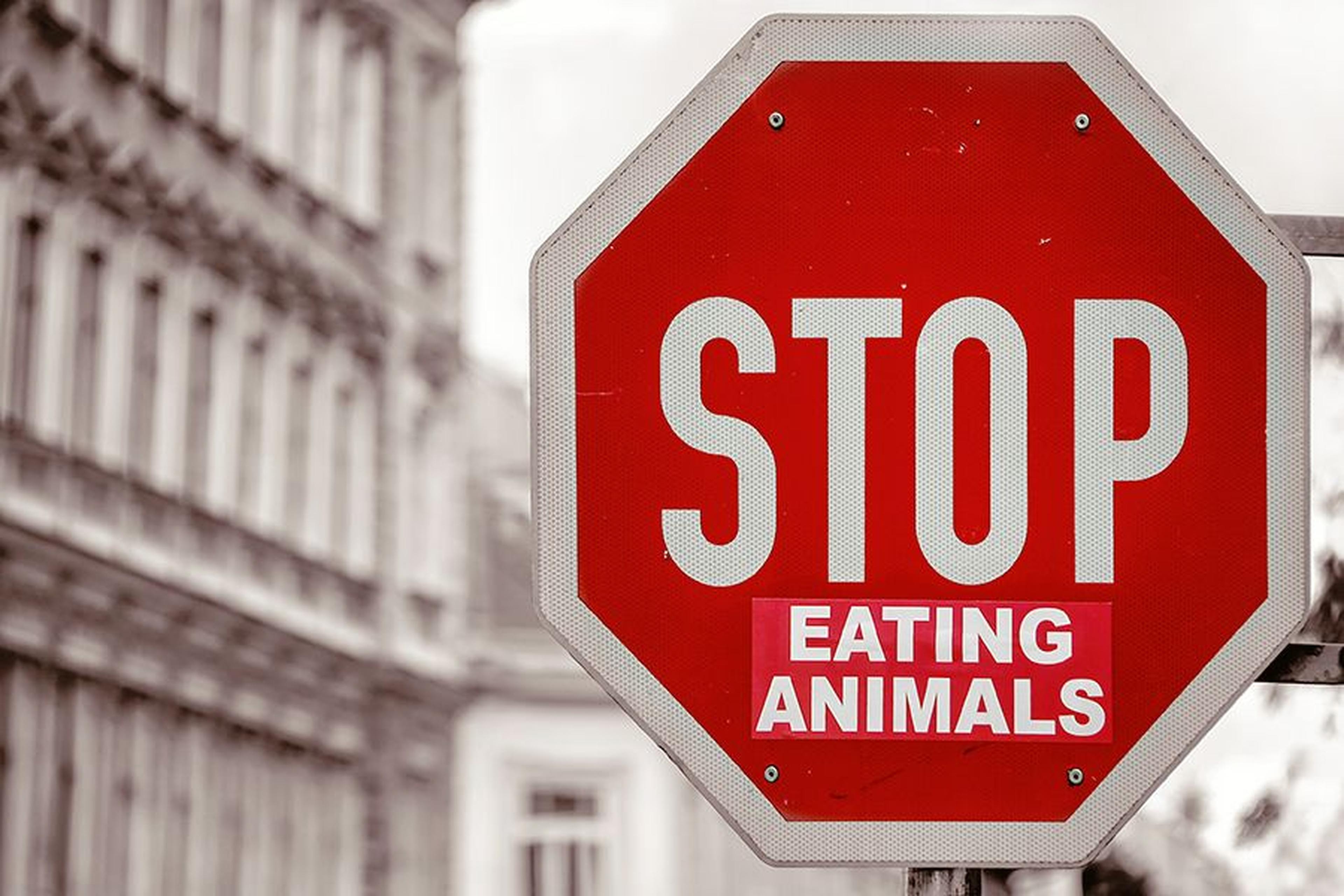 Stoppschild mit zusätzlichem Aufkleber „Eating Animals“.