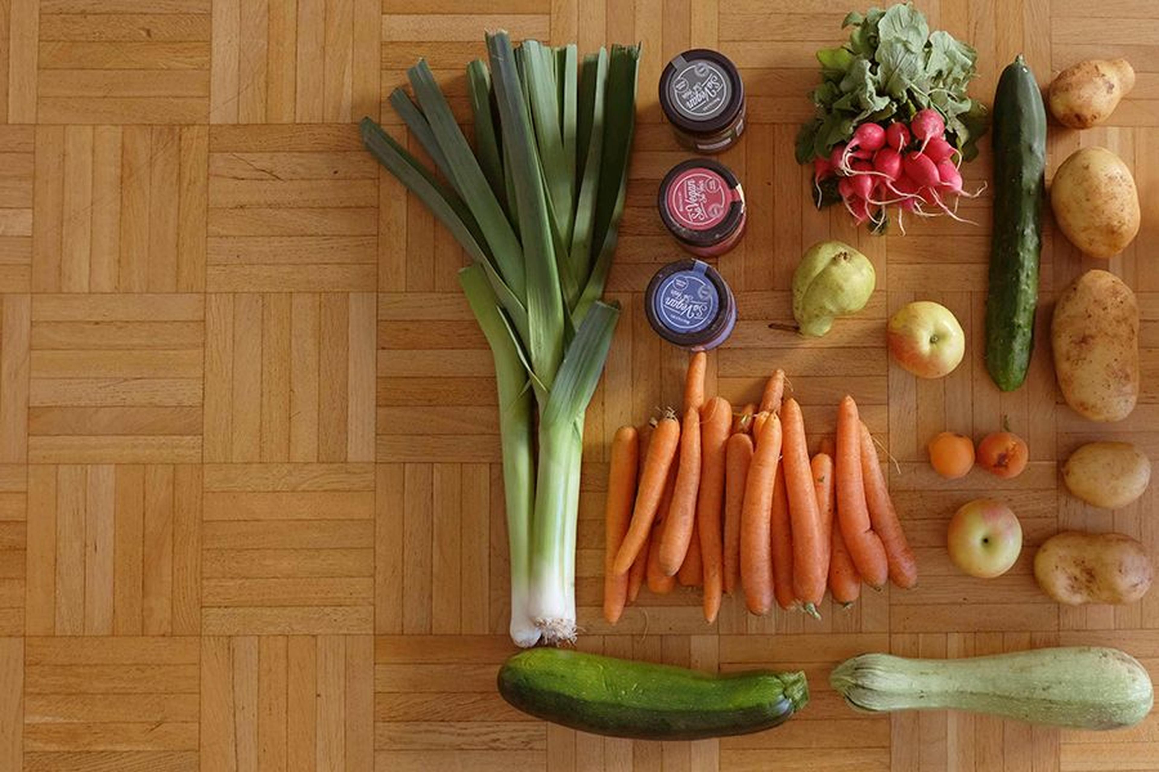 Selbst angebautes Gemüse wie Karotten, Lauch und Kartoffeln auf Holzboden