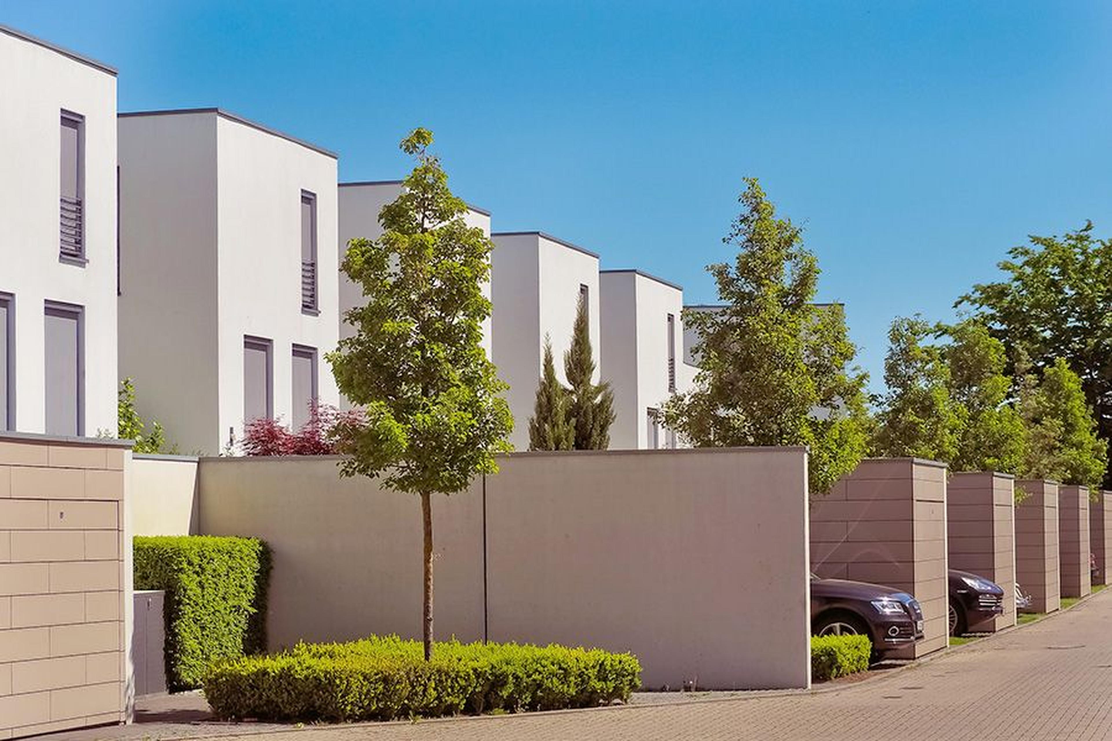 Eine Reihe moderner Häuser mit Vorgärten und identischem Aufbau.