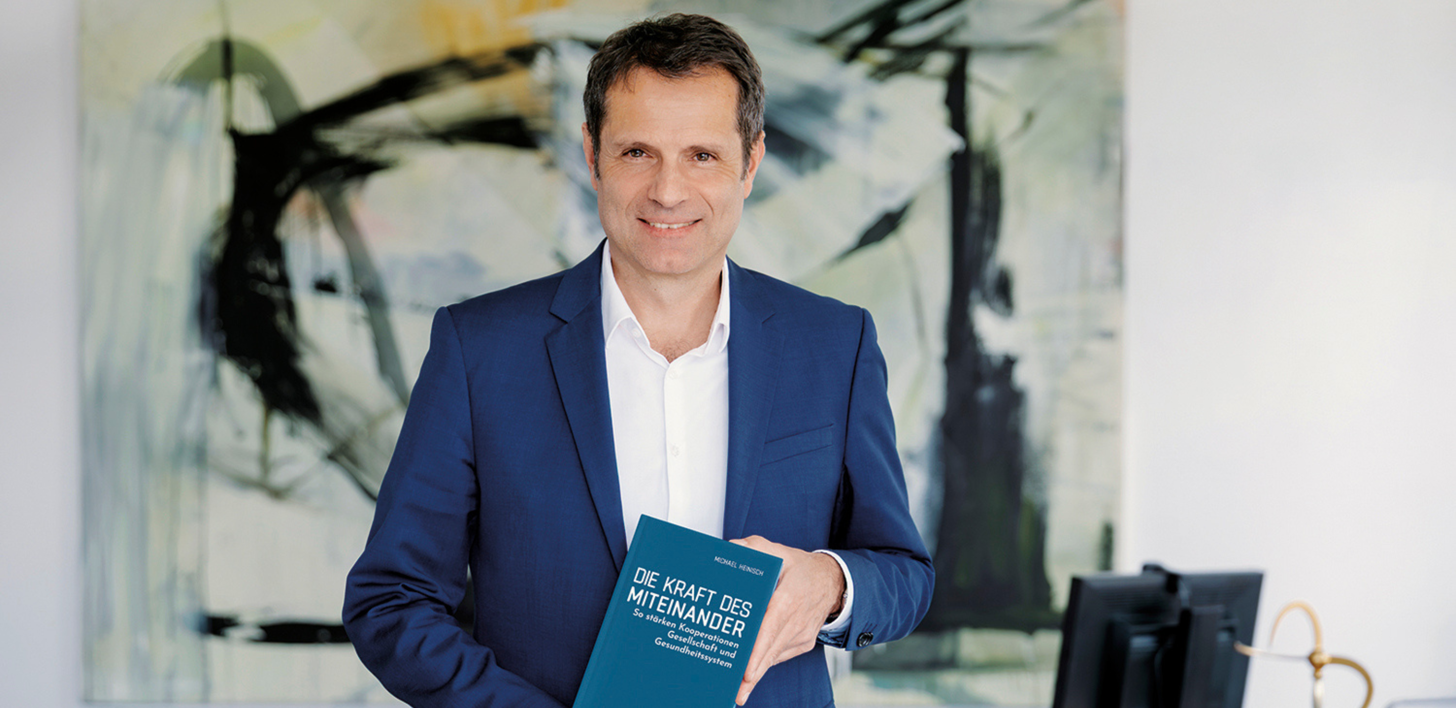 Dr. Michael Heinisch mit seinem Buch Miteinander statt nebeneinander in der Hand.