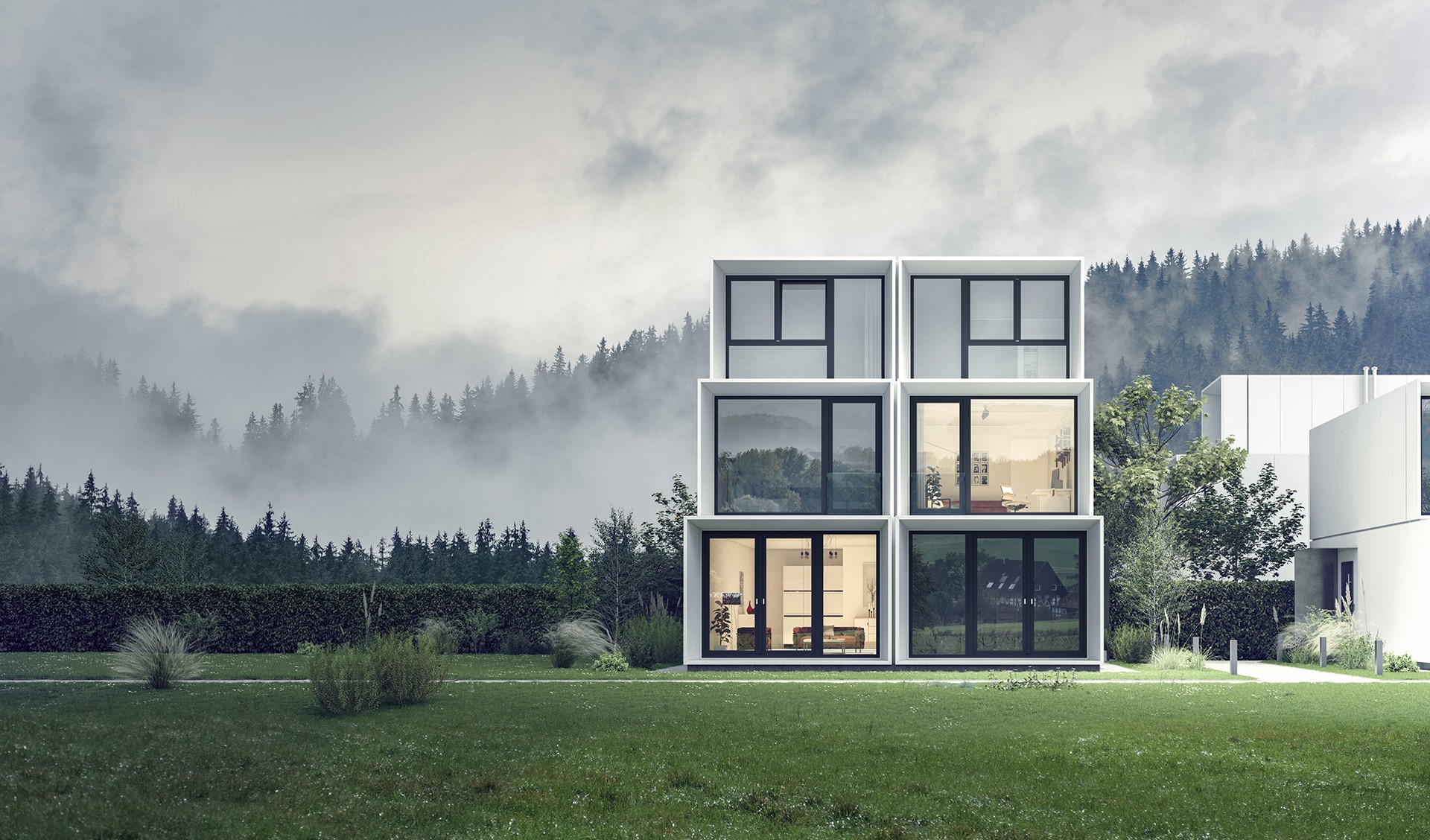 Una casa moderna con ventanas y puertas de vidrio, rodeada por un campo de césped y un bosque al fondo.