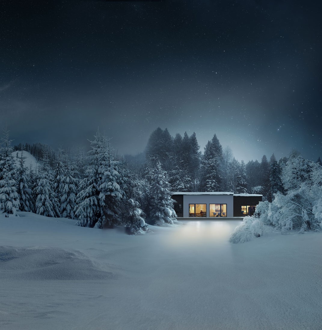 A modern house with large windows is surrounded by snow-covered trees and a snowy landscape at night.