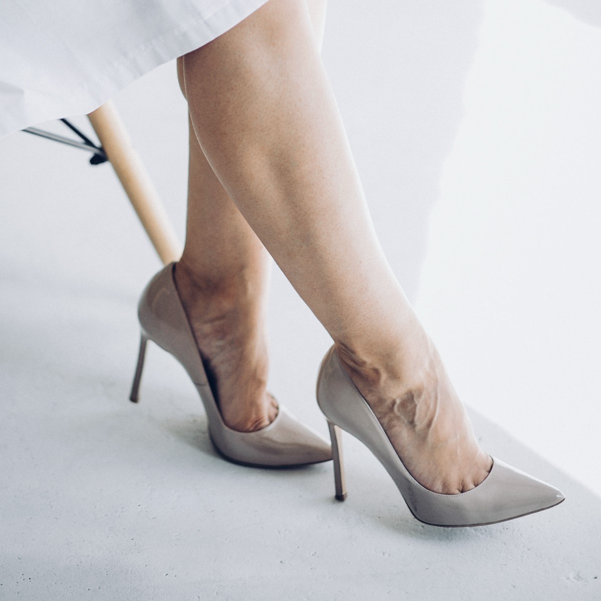 A woman's legs in high heels, with one foot slightly raised and the other foot on the ground.