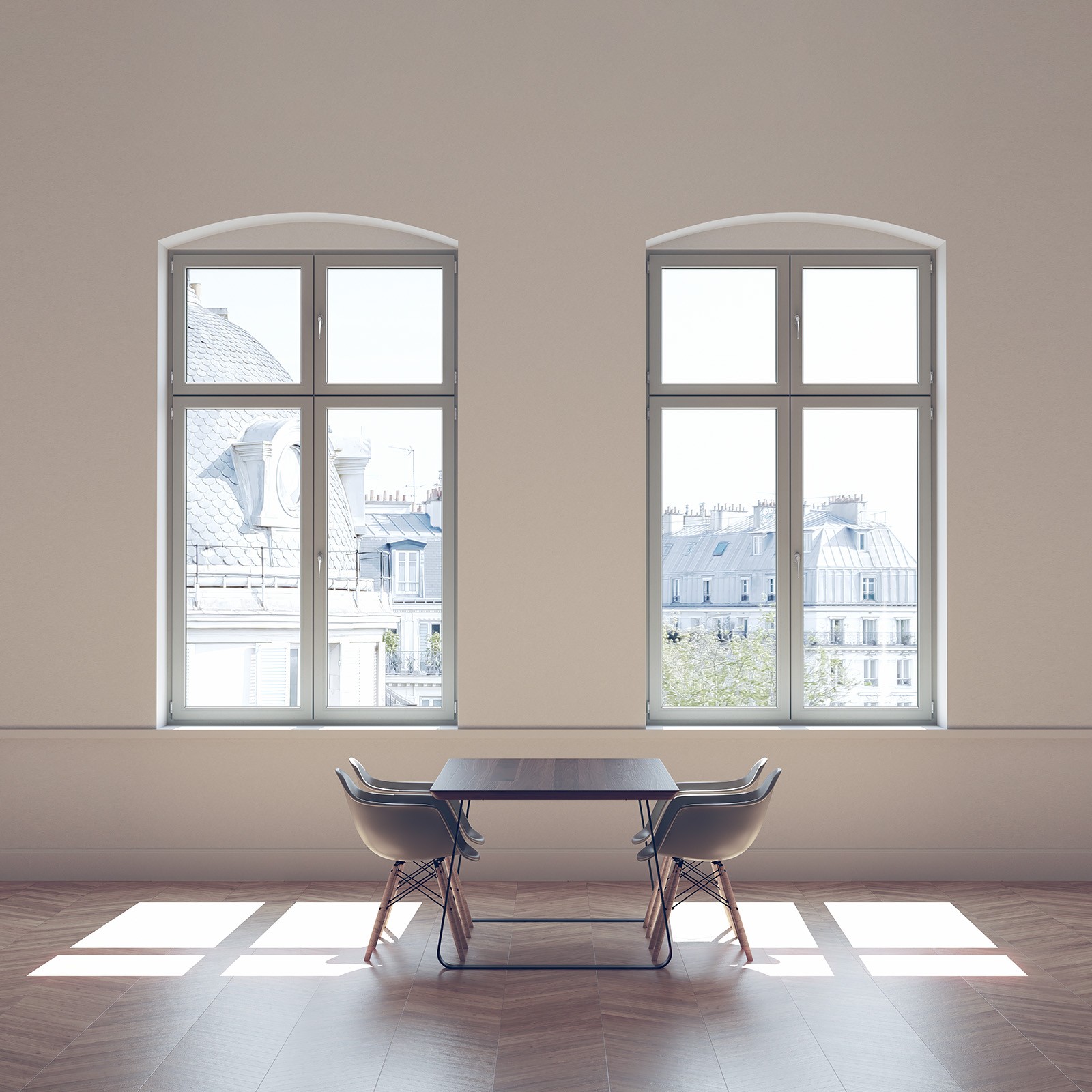 Habitación vacía con dos grandes ventanas, una mesa y sillas, y la luz del sol entrando.