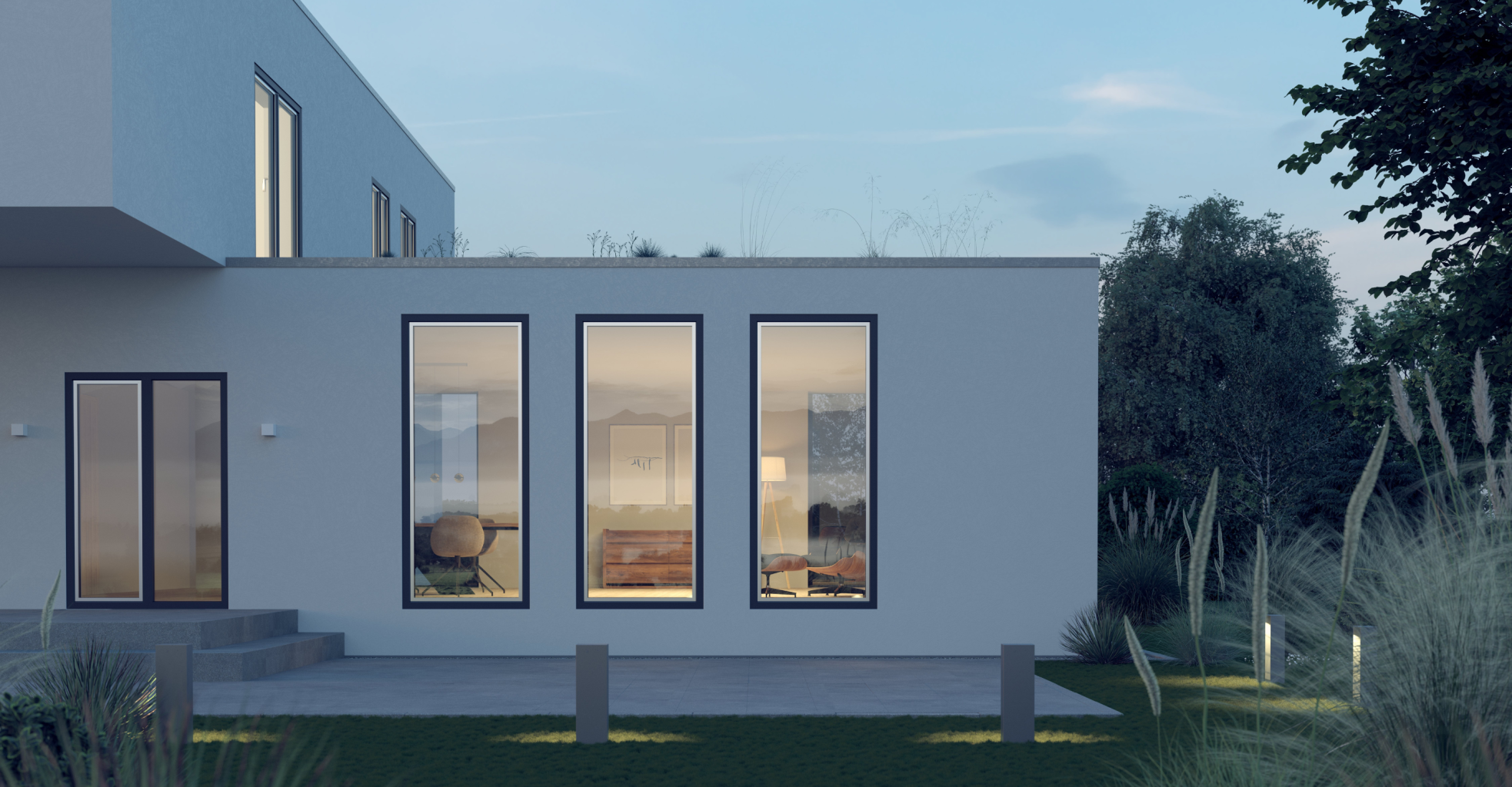 Modern house with large windows and a patio area, surrounded by tall grass and trees under a clear sky.