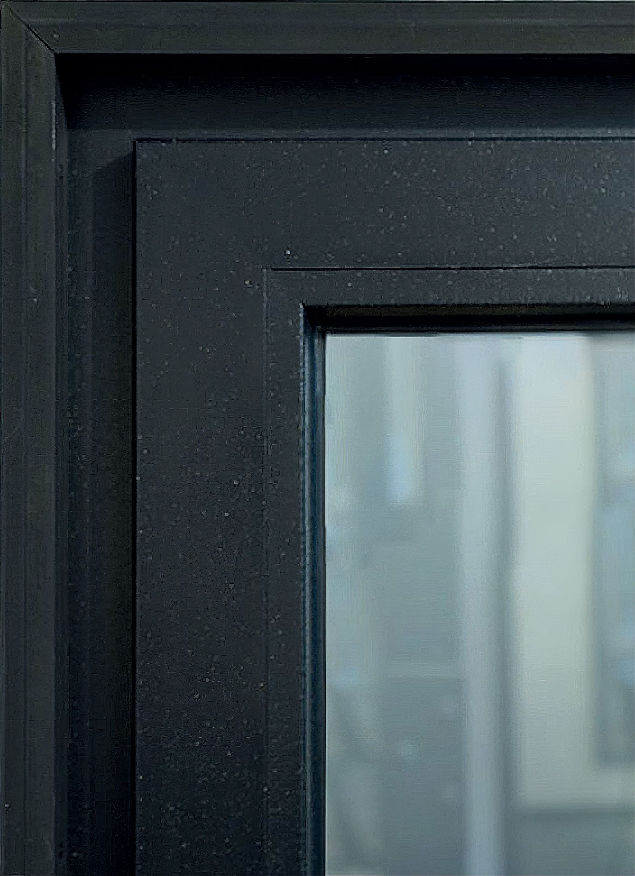 Black framed window with a clear glass panel, showcasing a blurred view of an interior space.