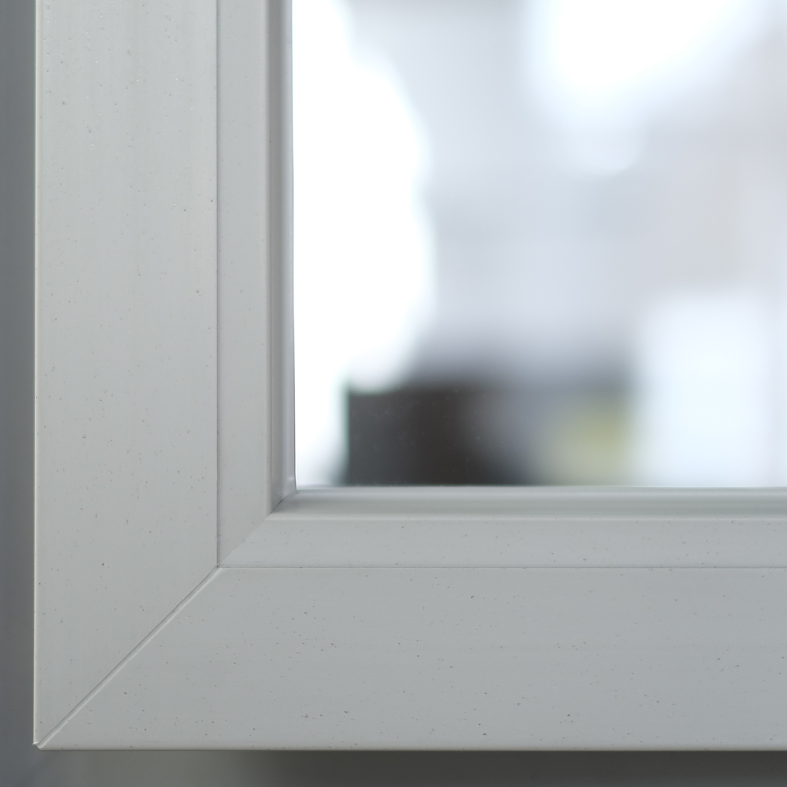 White frame of a window with a blurred view of a room inside.
