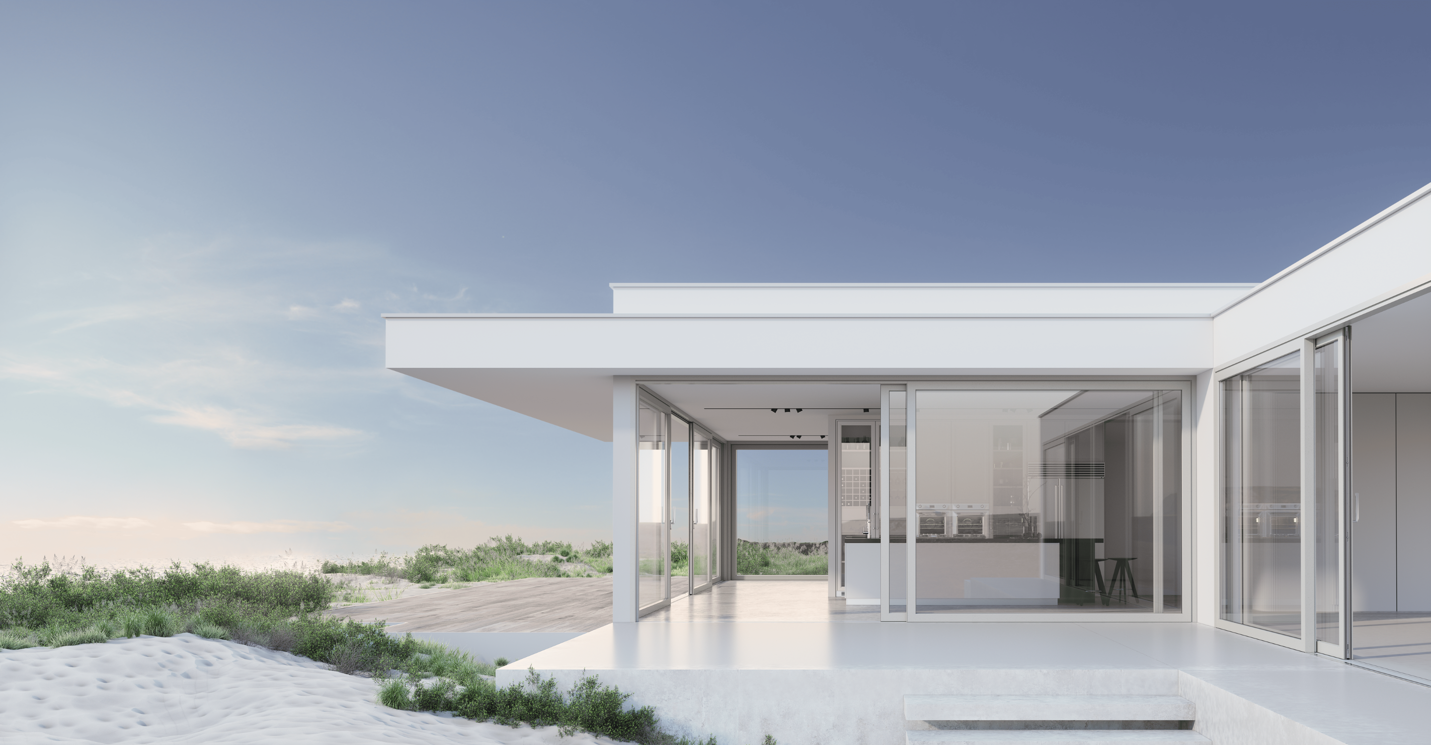 Casa blanca moderna con puertas y ventanas de vidrio, situada en una playa de arena con un cielo azul claro en el fondo.