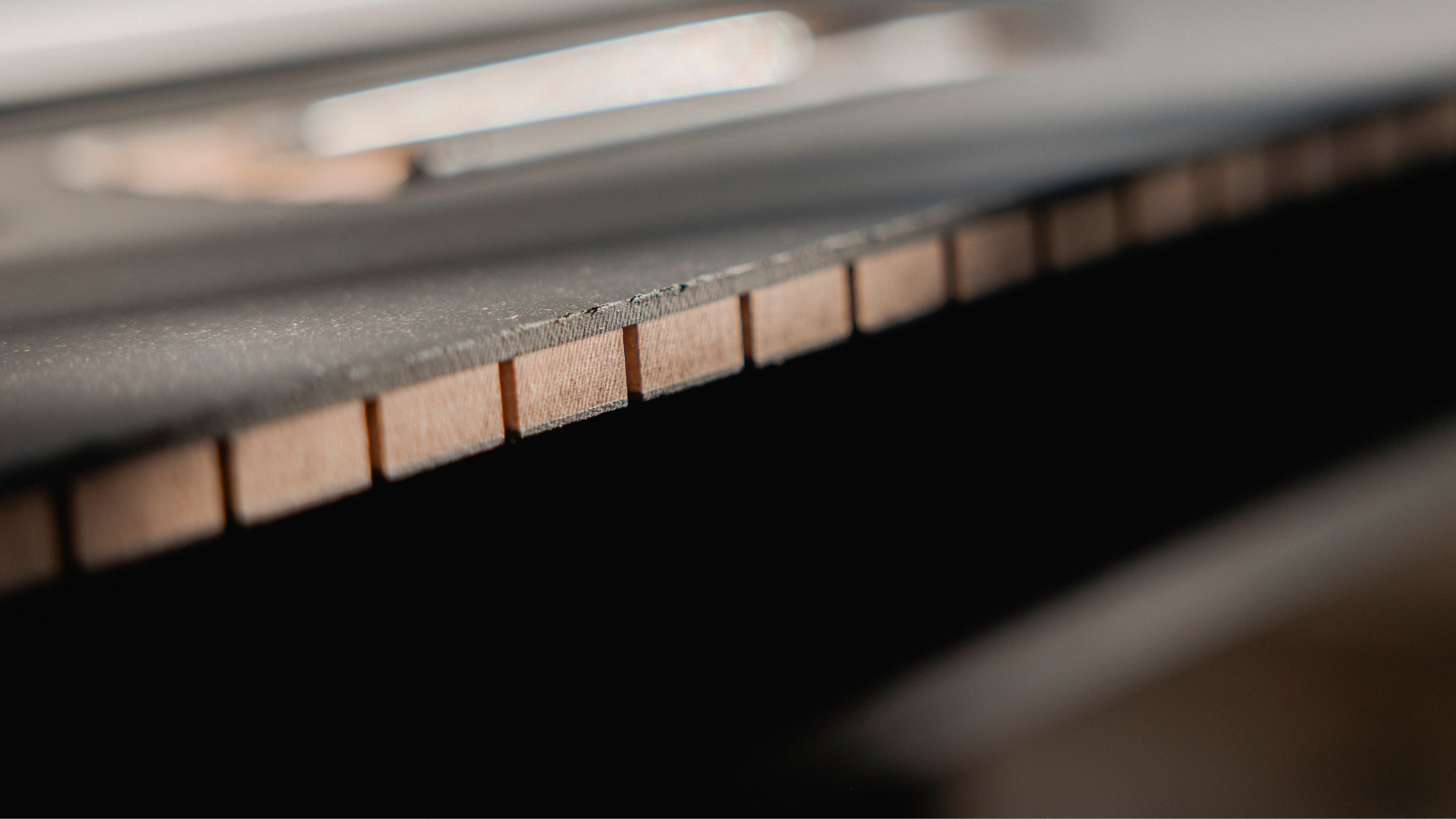 Close-up view of a piano keyboard with wooden keys and a black surface, showcasing the intricate details of the instrument.