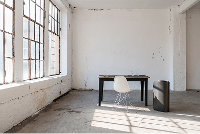 Leeres Büro mit großen Fenstern, einem Schreibtisch und einem Stuhl.