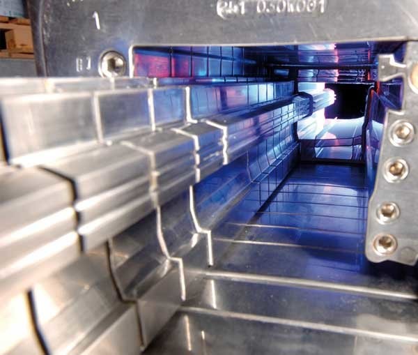 A close-up view of a stainless steel structure with a blue light illuminating the interior, possibly a part of a machine or equipment.