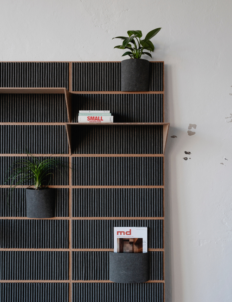 A wooden shelf with two potted plants and books. One of the books is titled "SMALL" and the other has "md" on the cover.