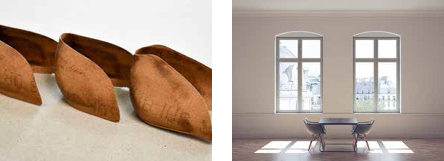 Rust-colored ceramic shapes on a surface next to a minimalist room with two large windows, a table, and chairs, overlooking a cityscape.
