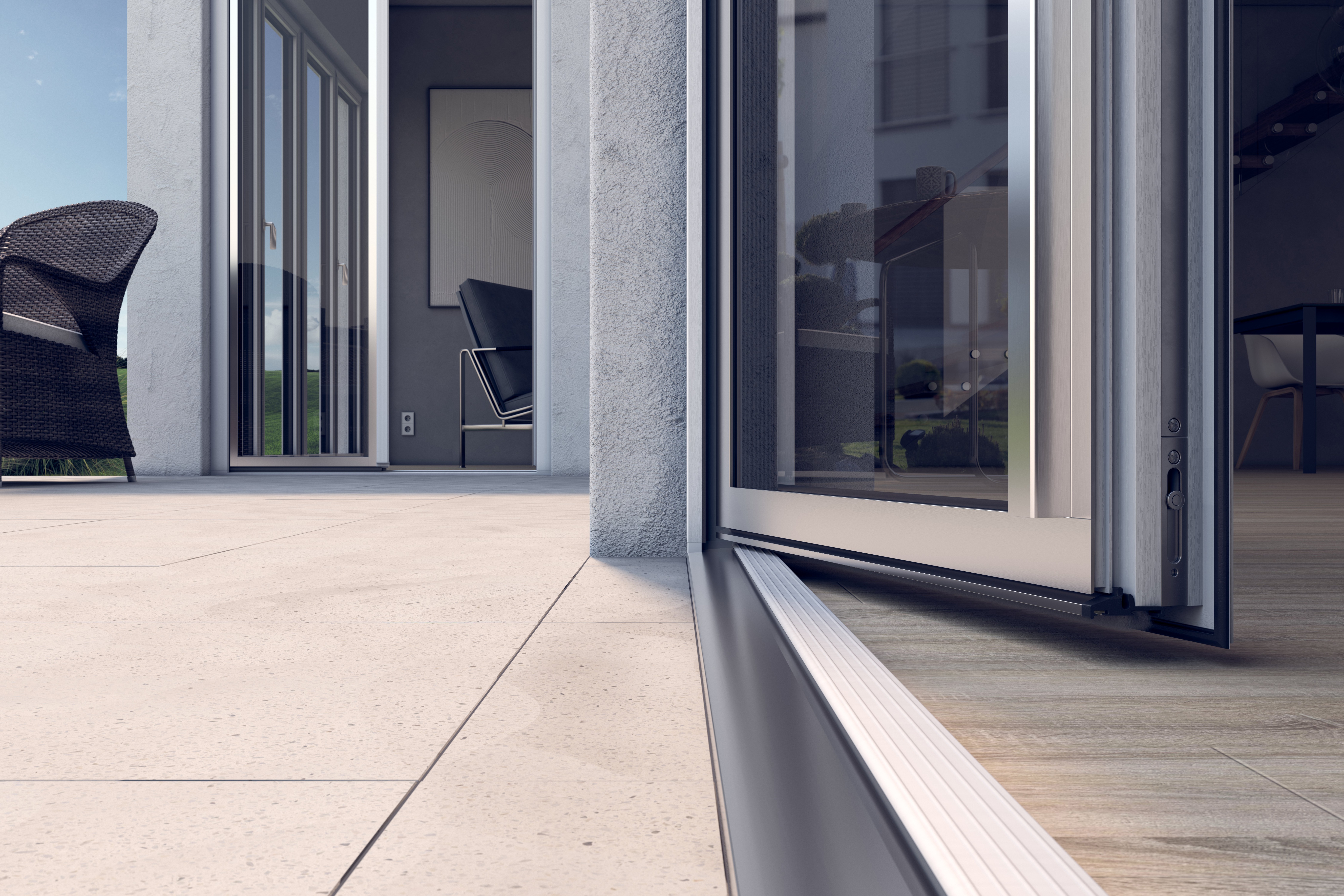 Puerta corrediza de vidrio con umbral, que conduce a un patio con una silla de mimbre y una vista de un campo de césped.