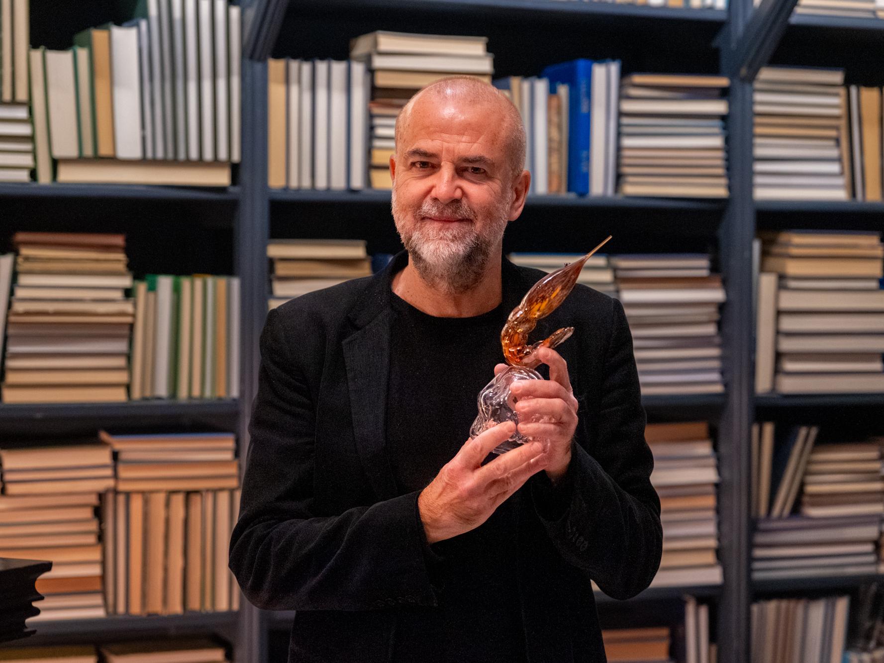 Porträttbild på Lars Jönsson som håller upp priset Den Gyllene Räkan