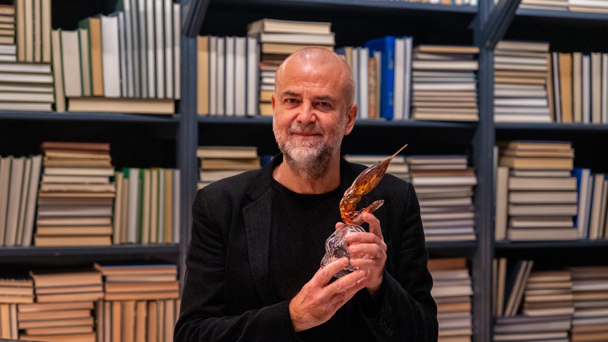 Porträttbild på Lars Jönsson som håller upp priset Den Gyllene Räkan