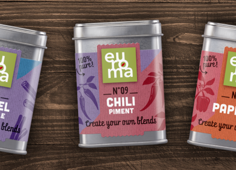 Three colorful Euroma spice tins labeled KANEEL, CHILI, and PAPRIKA on a wooden surface, with “Create your own blends” text.