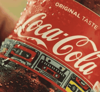 Close-up van een koude Coca-Cola-fles met condens, waarop het rode etiket en de tekst „Original Taste“ te zien zijn.