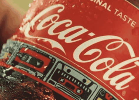 Close-up van een koude Coca-Cola-fles met condens, waarop het rode etiket en de tekst „Original Taste“ te zien zijn.