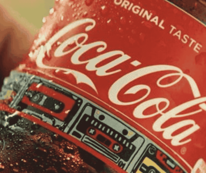 Close-up van een koude Coca-Cola-fles met condens, waarop het rode etiket en de tekst „Original Taste“ te zien zijn.