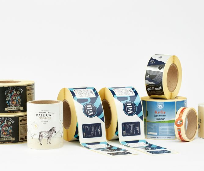 Assorted printed product label rolls in various sizes and colors displayed on a white background.