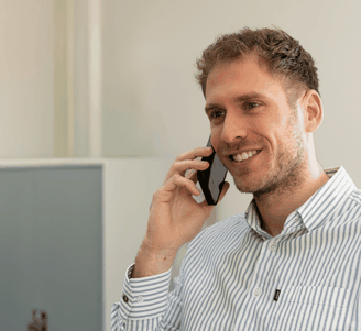 Medewerker lachend aan telefoon