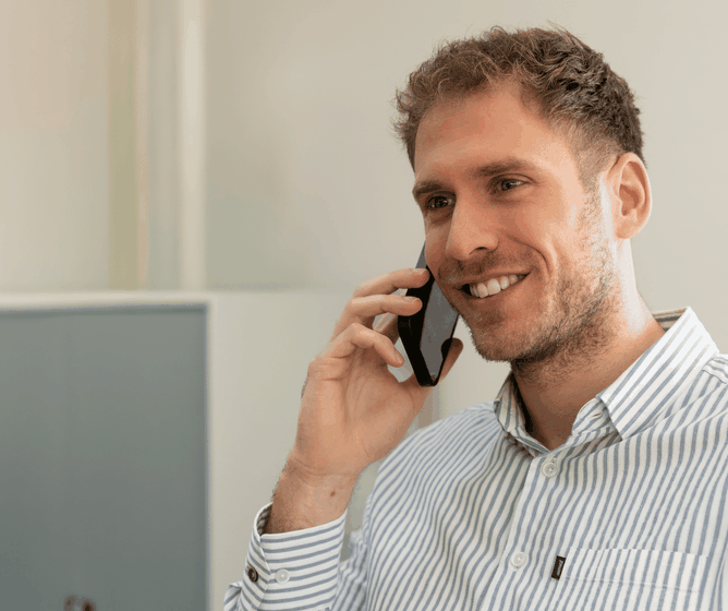 Medewerker lachend aan telefoon