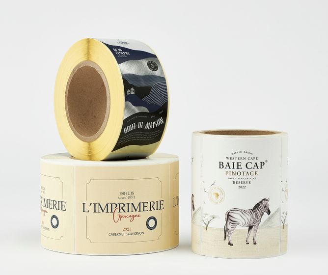 Three rolls of illustrated wine bottle labels, featuring minimalist landscapes and a zebra on clean white background.