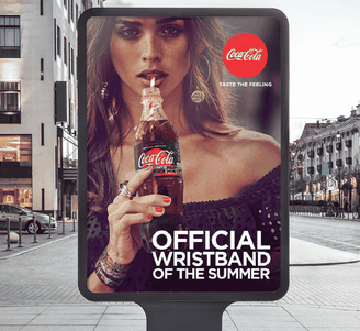 Reclame bij een bushalte waarop een vrouw te zien is die Coca-Cola uit een glazen fles drinkt, met de tekst: „De officiële polsband van de zomer.”