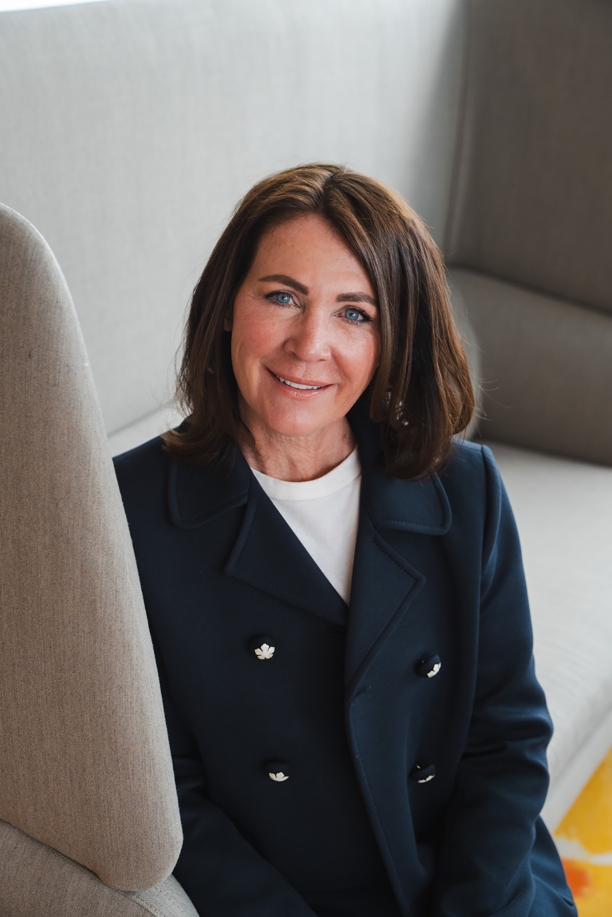 portret van een vrouw die op een bankje zit en naar de camera kijkt en glimlacht, de fotograaf staat hoger dan de vrouw